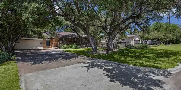 Image 2: Paved driveway approach leading up to the home, su