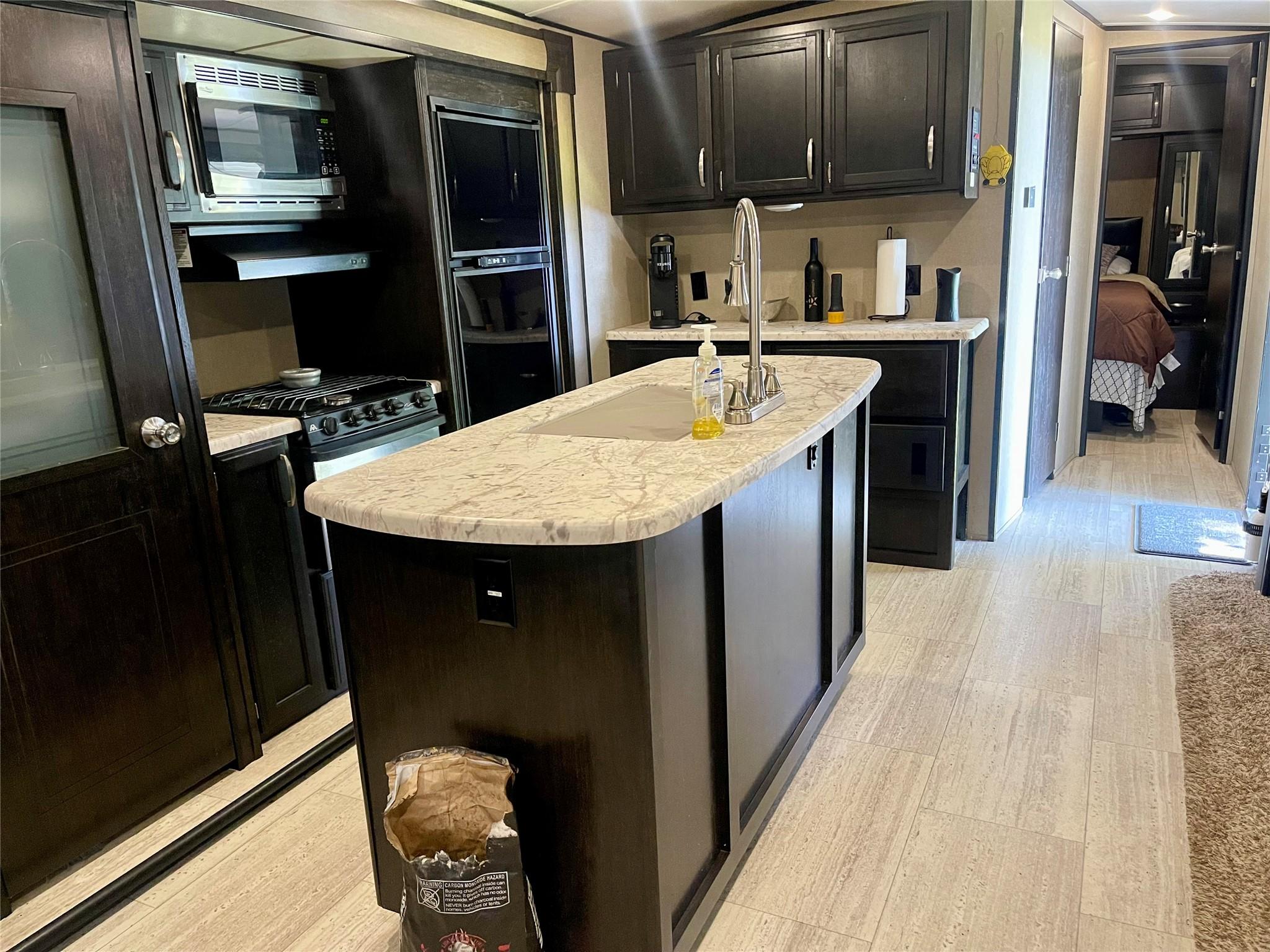 Image 4: This photo shows a modern kitchen space with dark