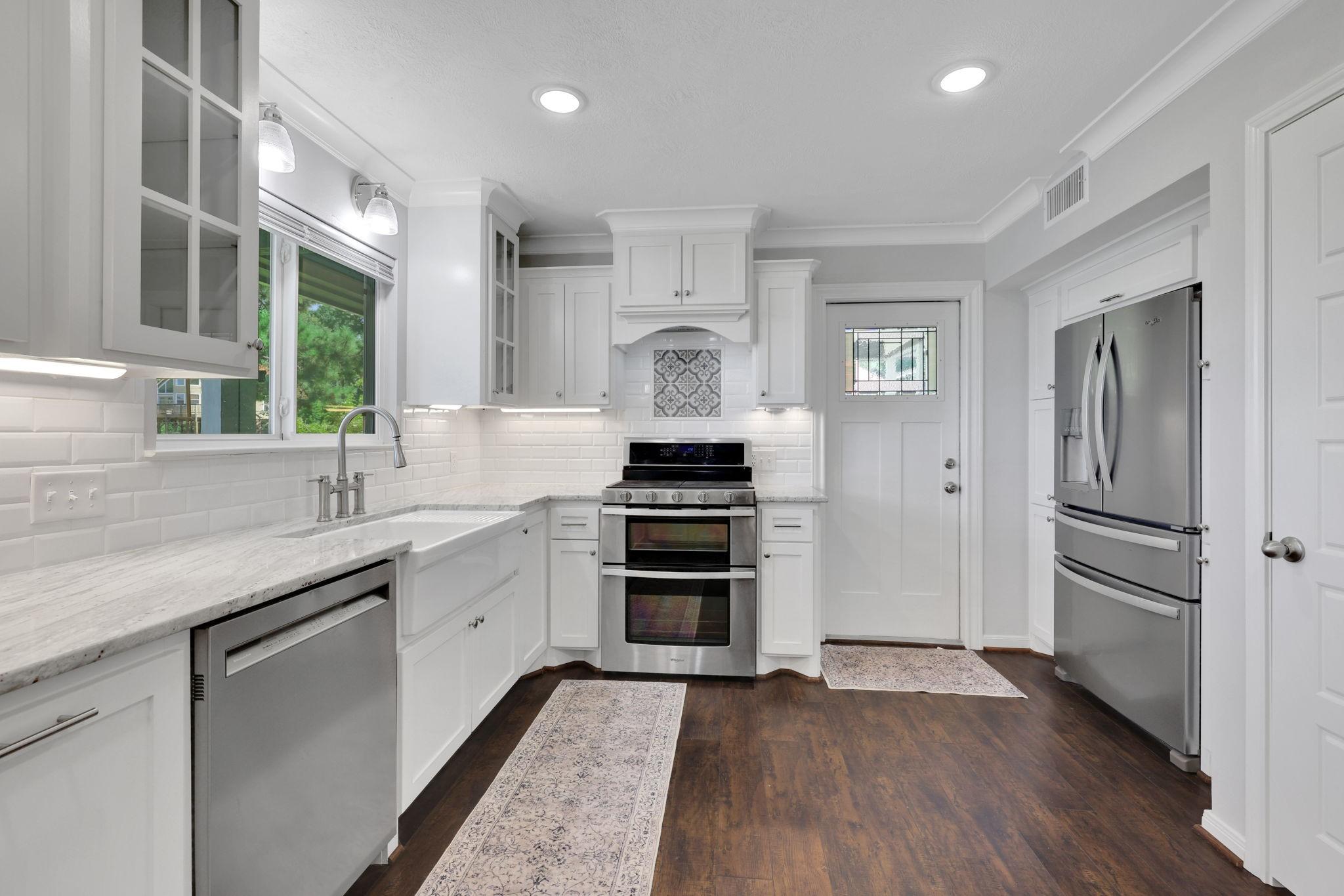 Image 4: The white cabinets, subway tile, and stainless app