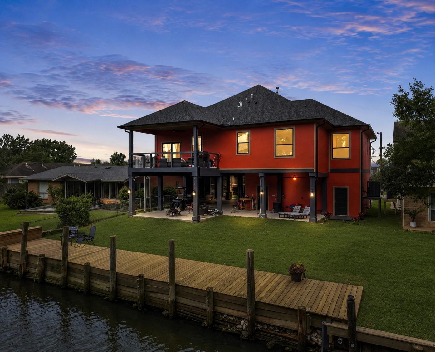 Image 2: This waterfront home features a vibrant exterior,