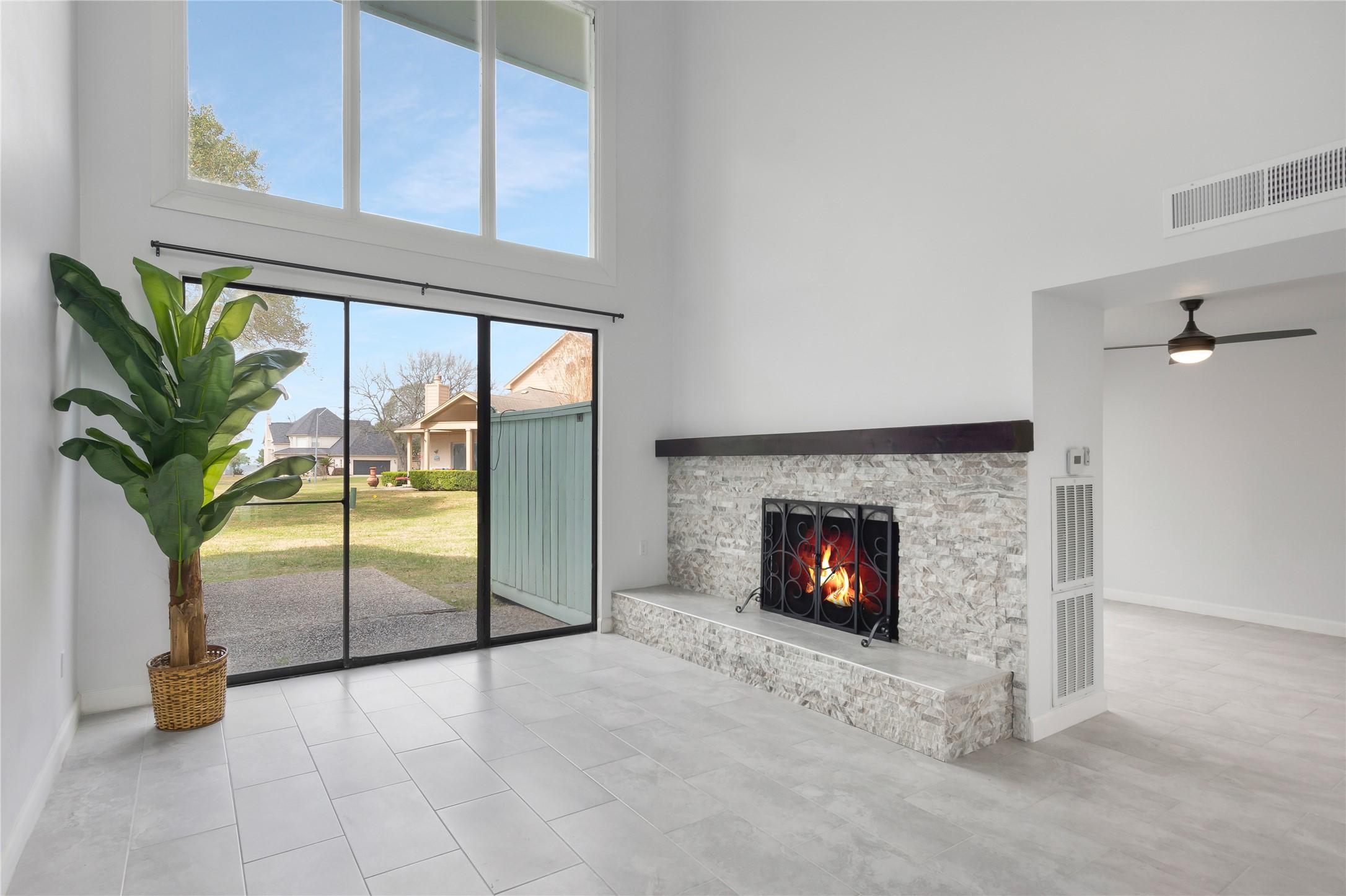 Image 2: Bright living area features soaring windows, a woo