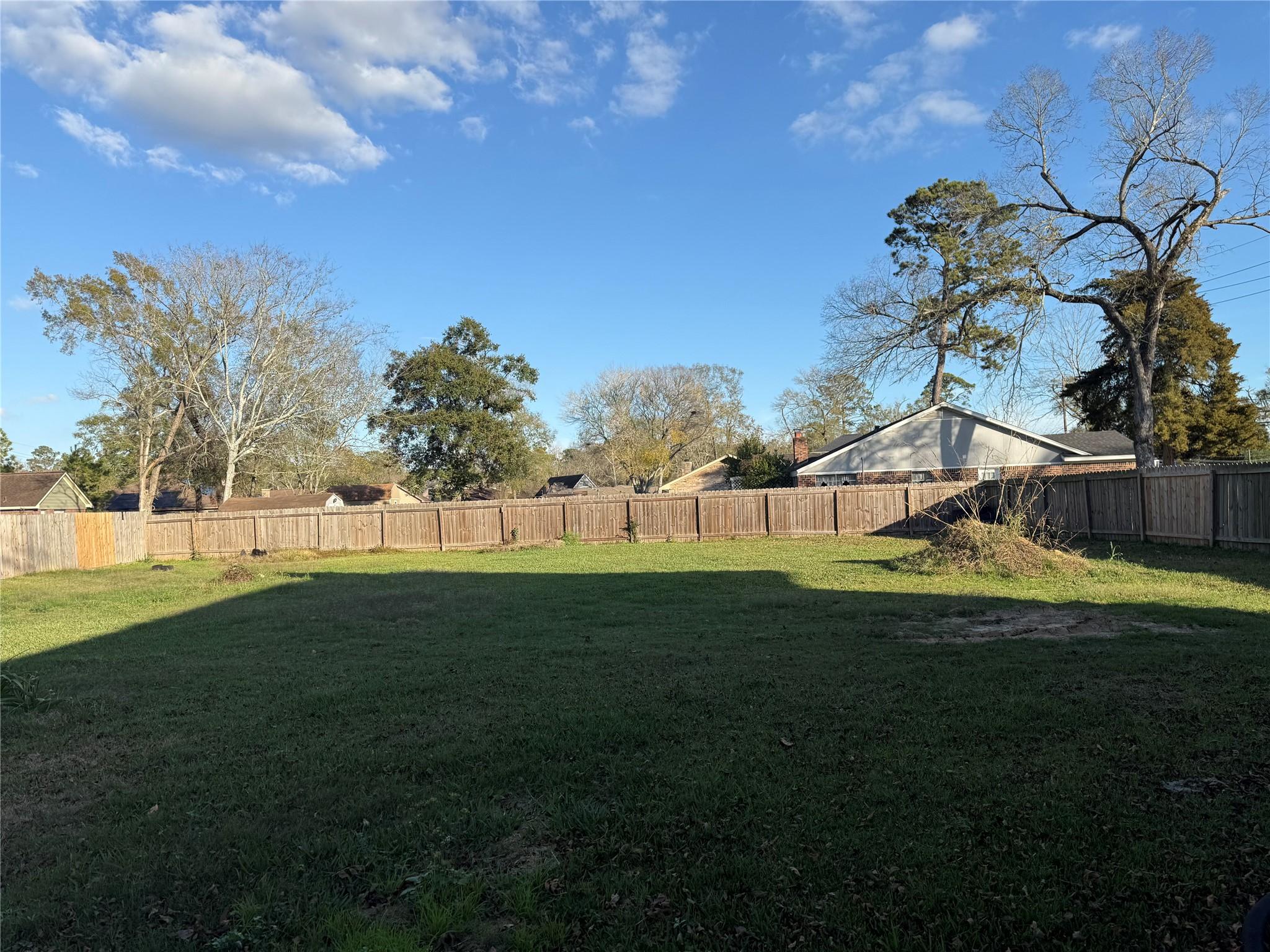 Image 1: Spacious backyard with a well-maintained lawn, sur