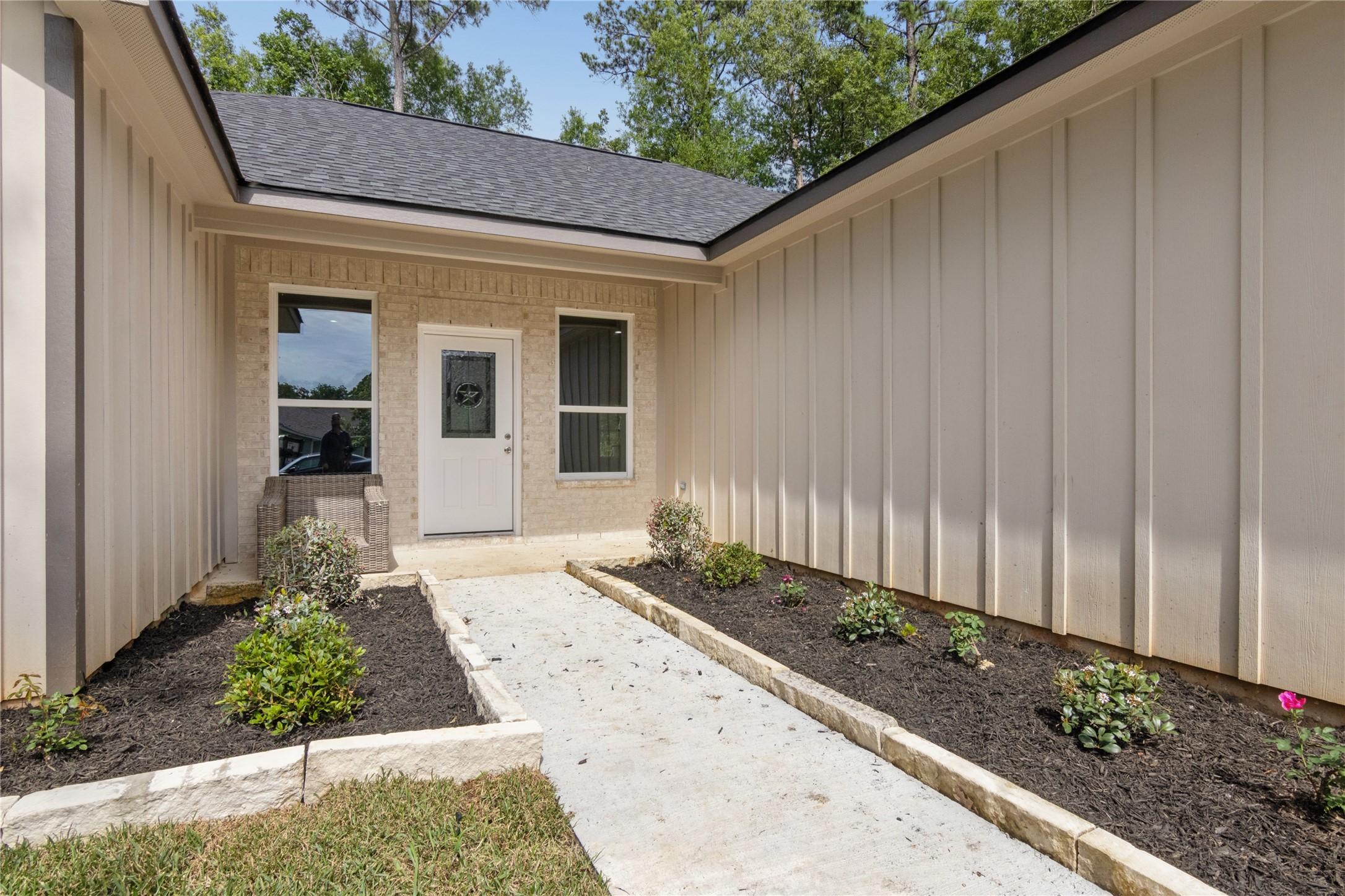 Image 2: Modern single-story home with a light brick facad