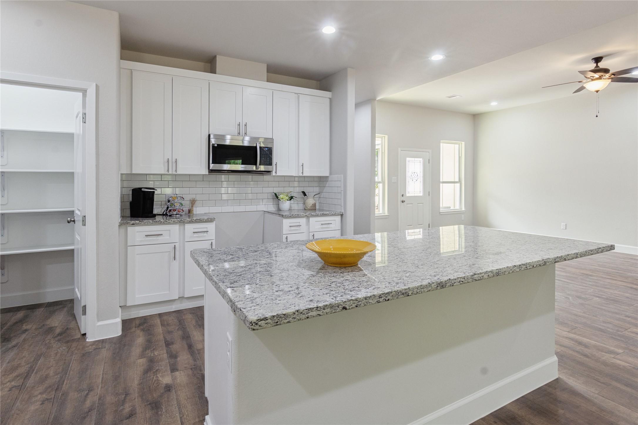 Image 4: This kitchen boasts a stunning granite island, per