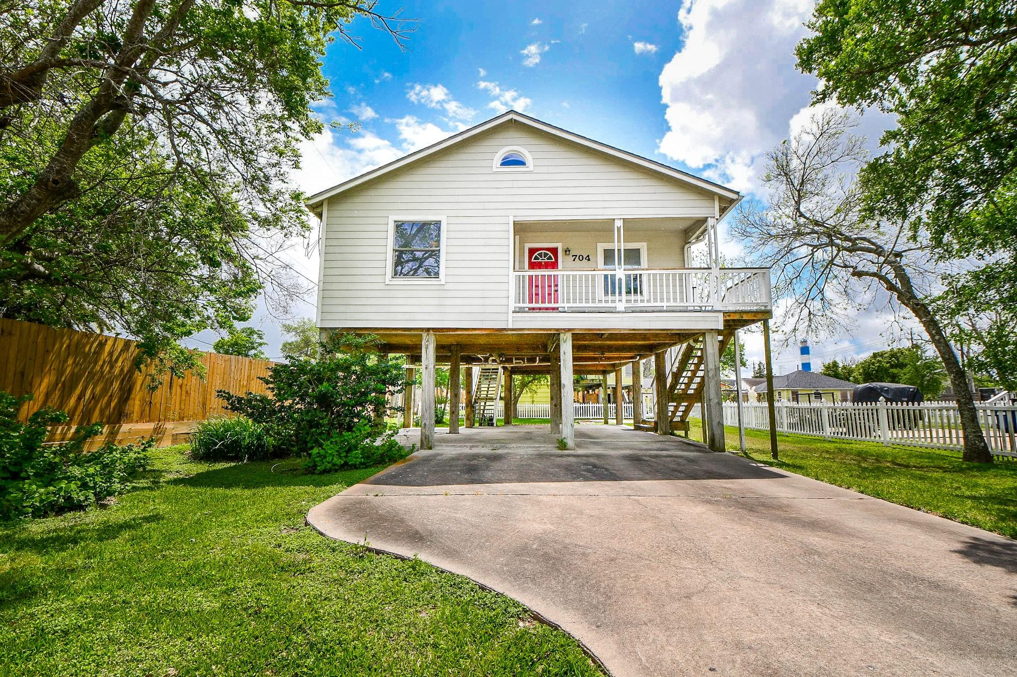 Image 2: This elevated home features a charming front porch