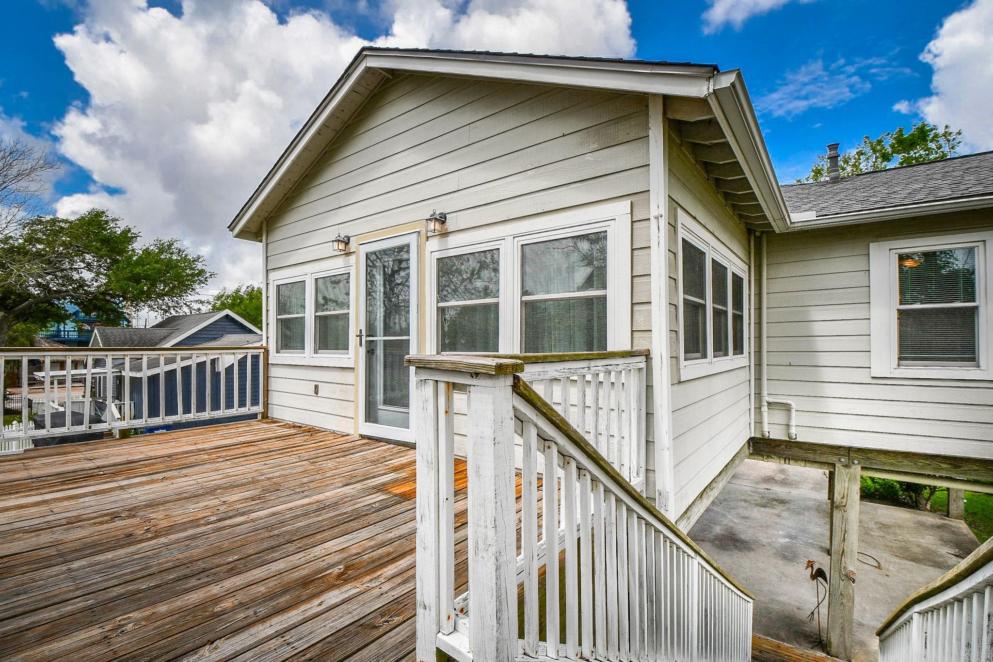 Image 4: This home features a spacious wooden deck with a s