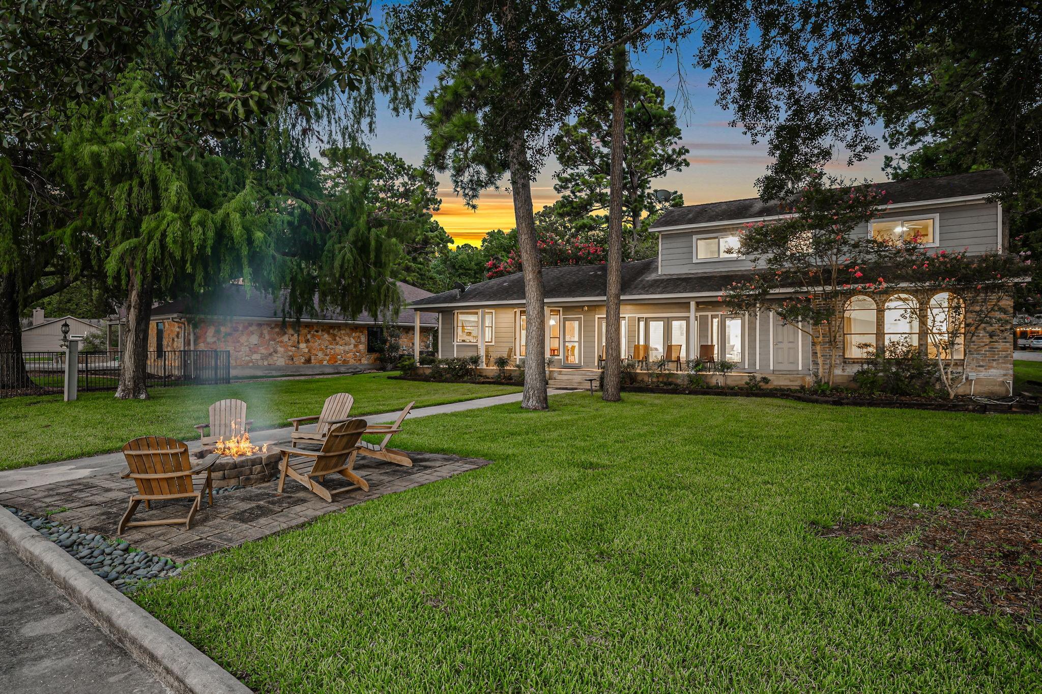 Image 3: The home is surrounded by mature trees that provid