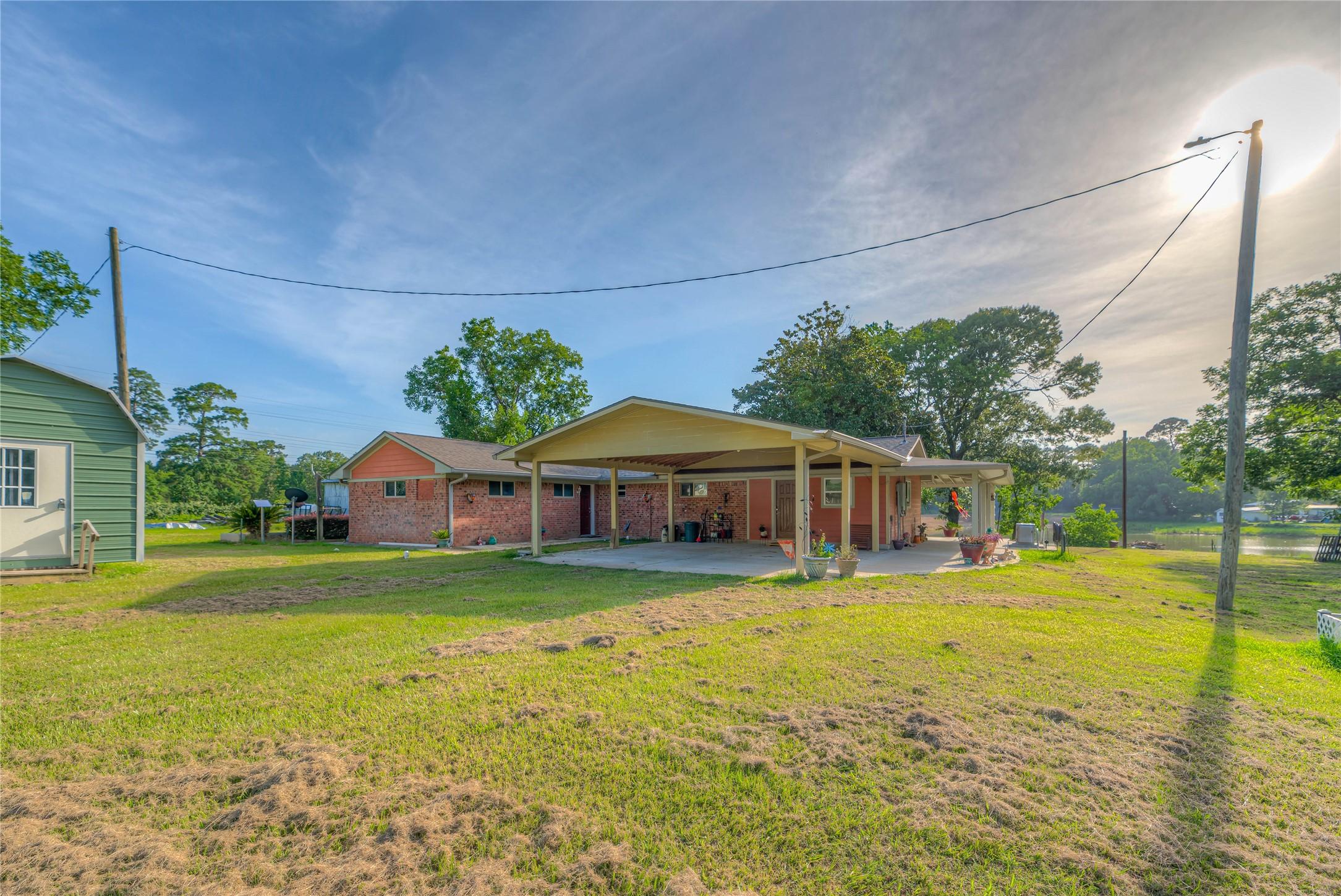 Image 1: front of home - 2 car carport & storage shed to th