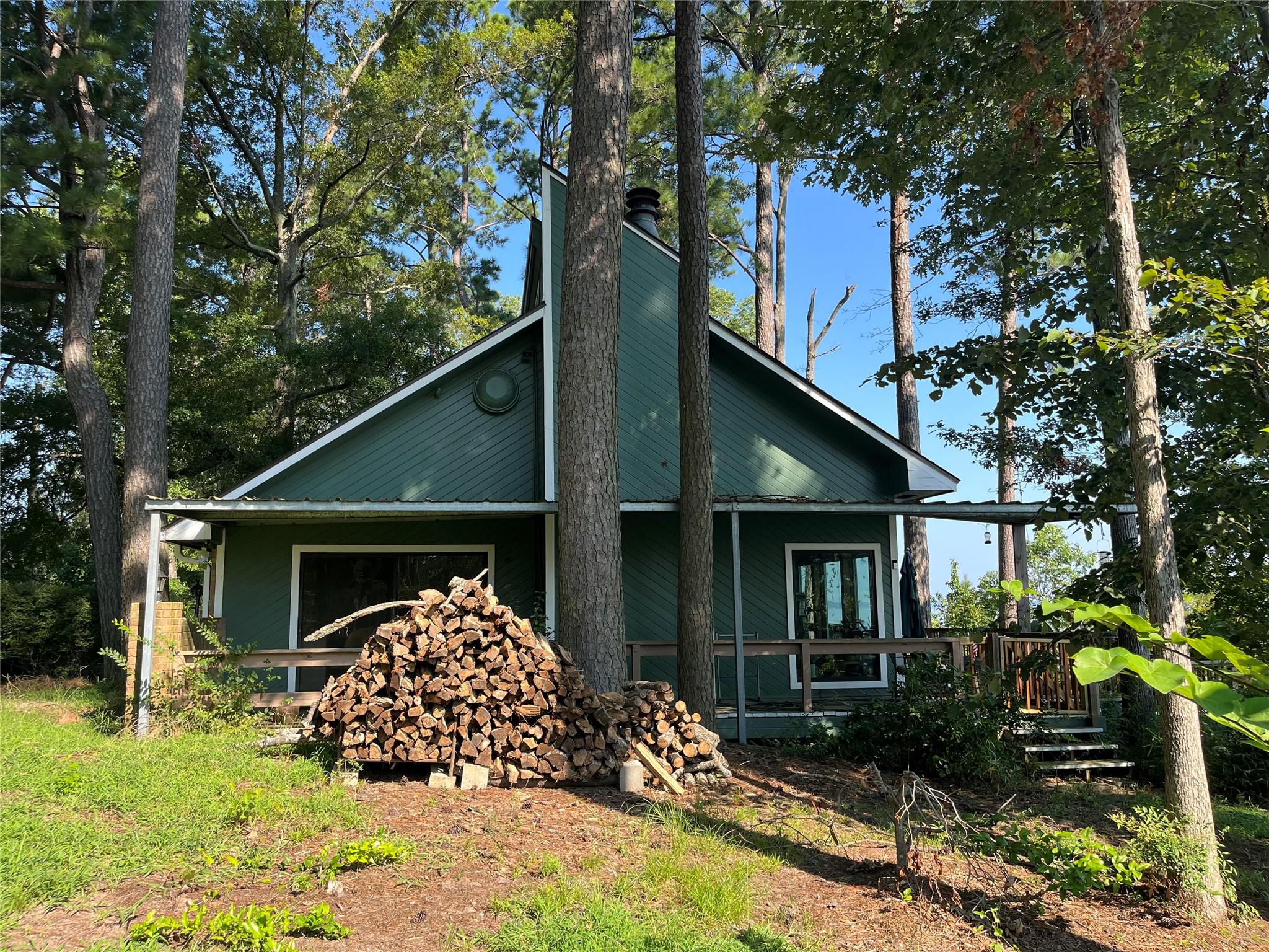 Image 4: Side view of home nestled in forest like setting.