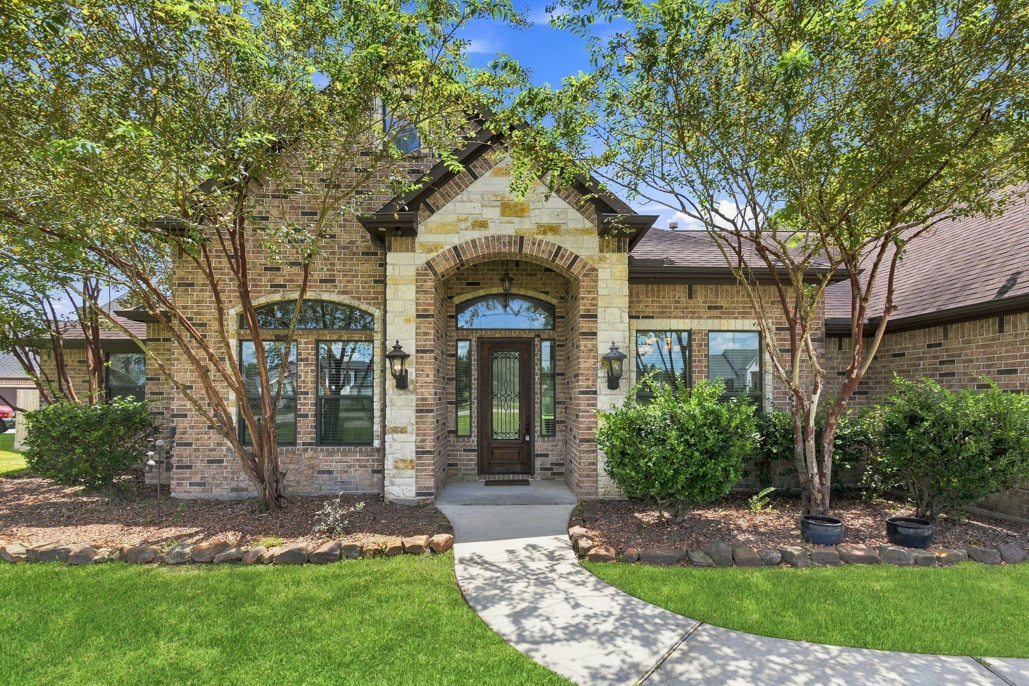 Image 2: Charming brick home featuring a welcoming arched e