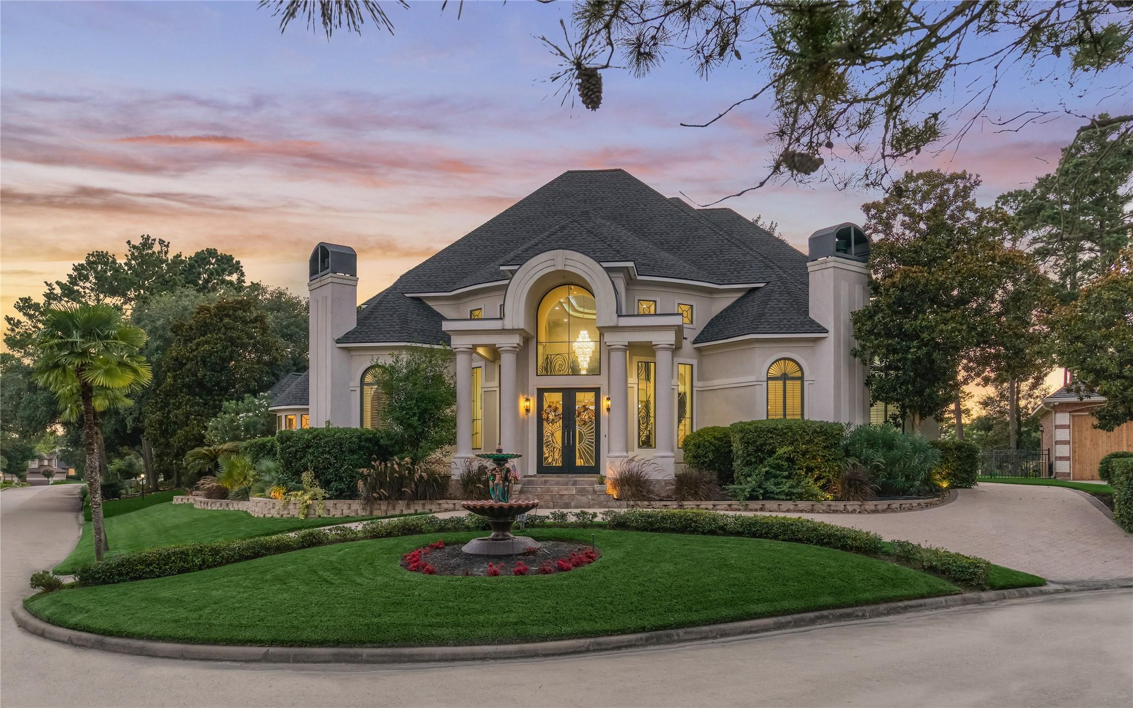 Image 1: A grand circular driveway leads to this custom-bui