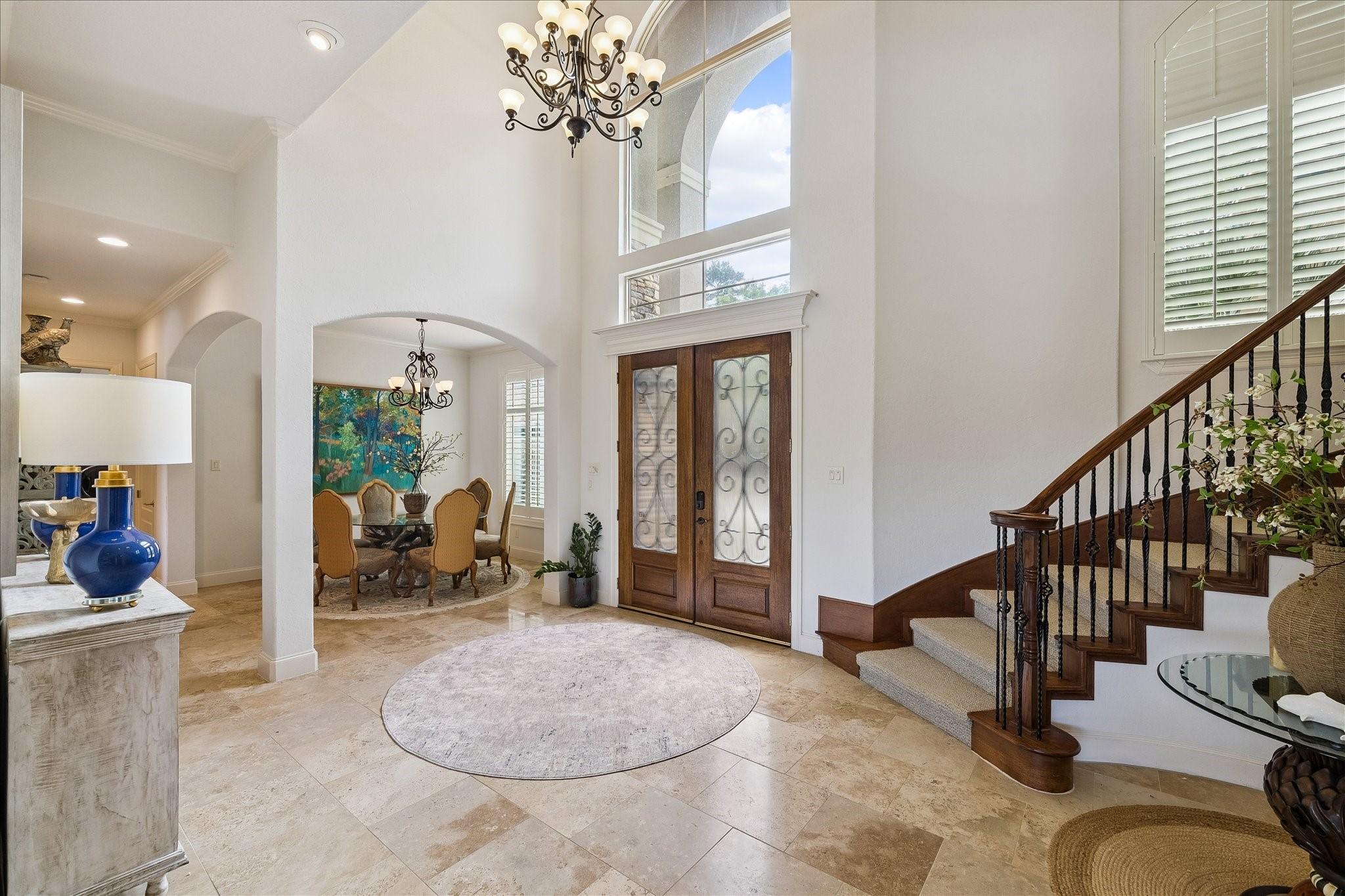 Image 3: Two-story foyer with spiral staircase and traverti