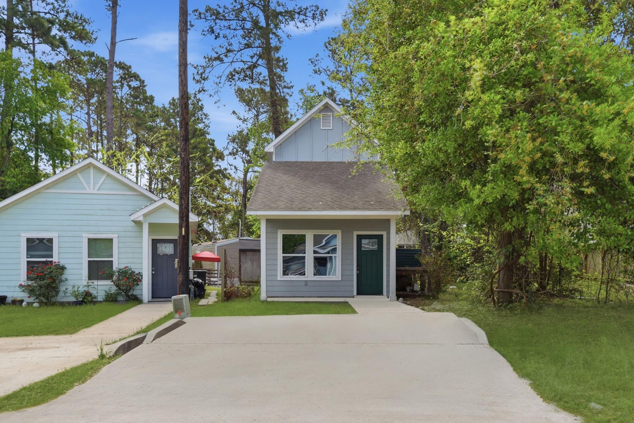 Image 1: Charming home with a simple gray exterior, green f