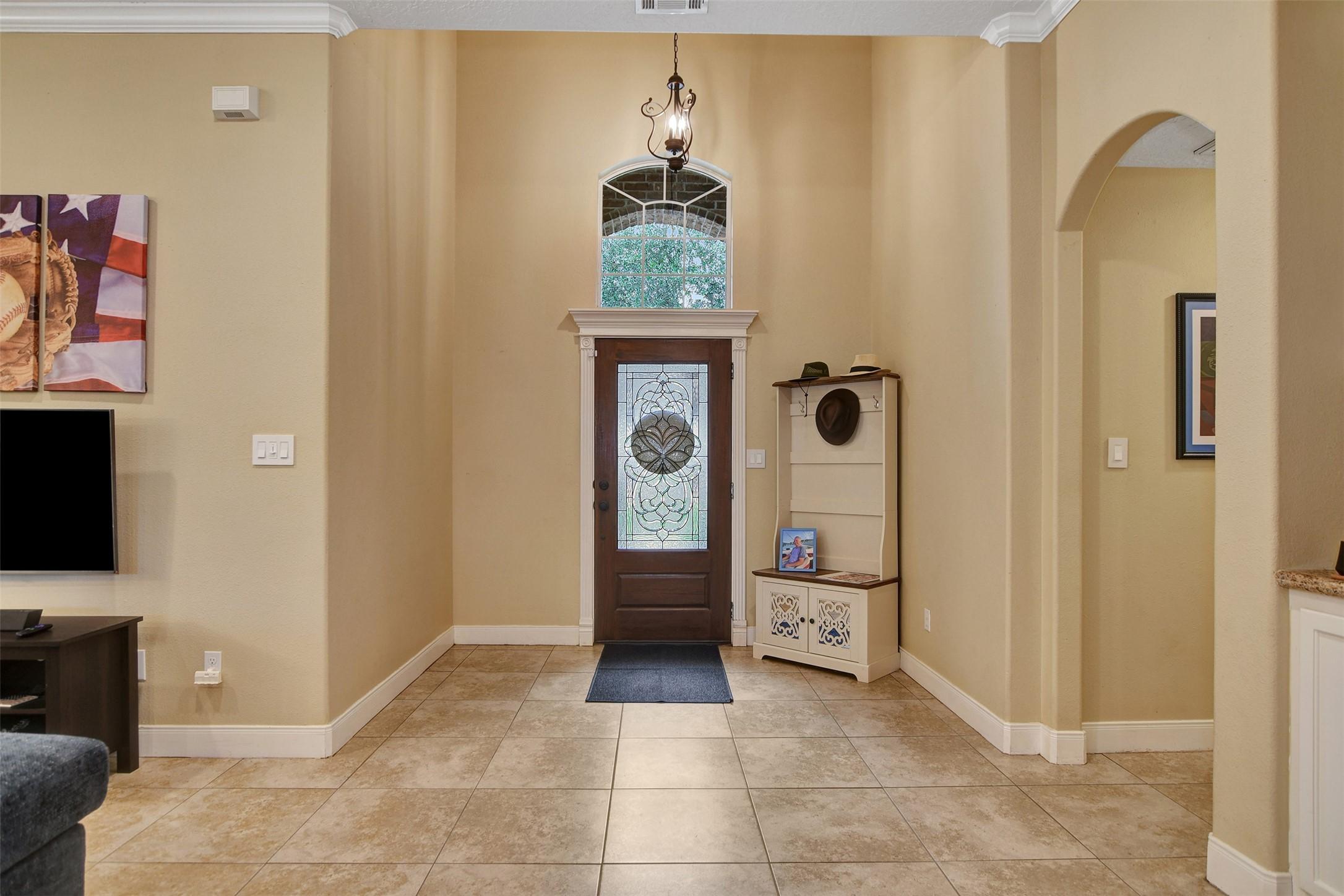 Image 4: Welcoming tiled entry with natural light and foyer