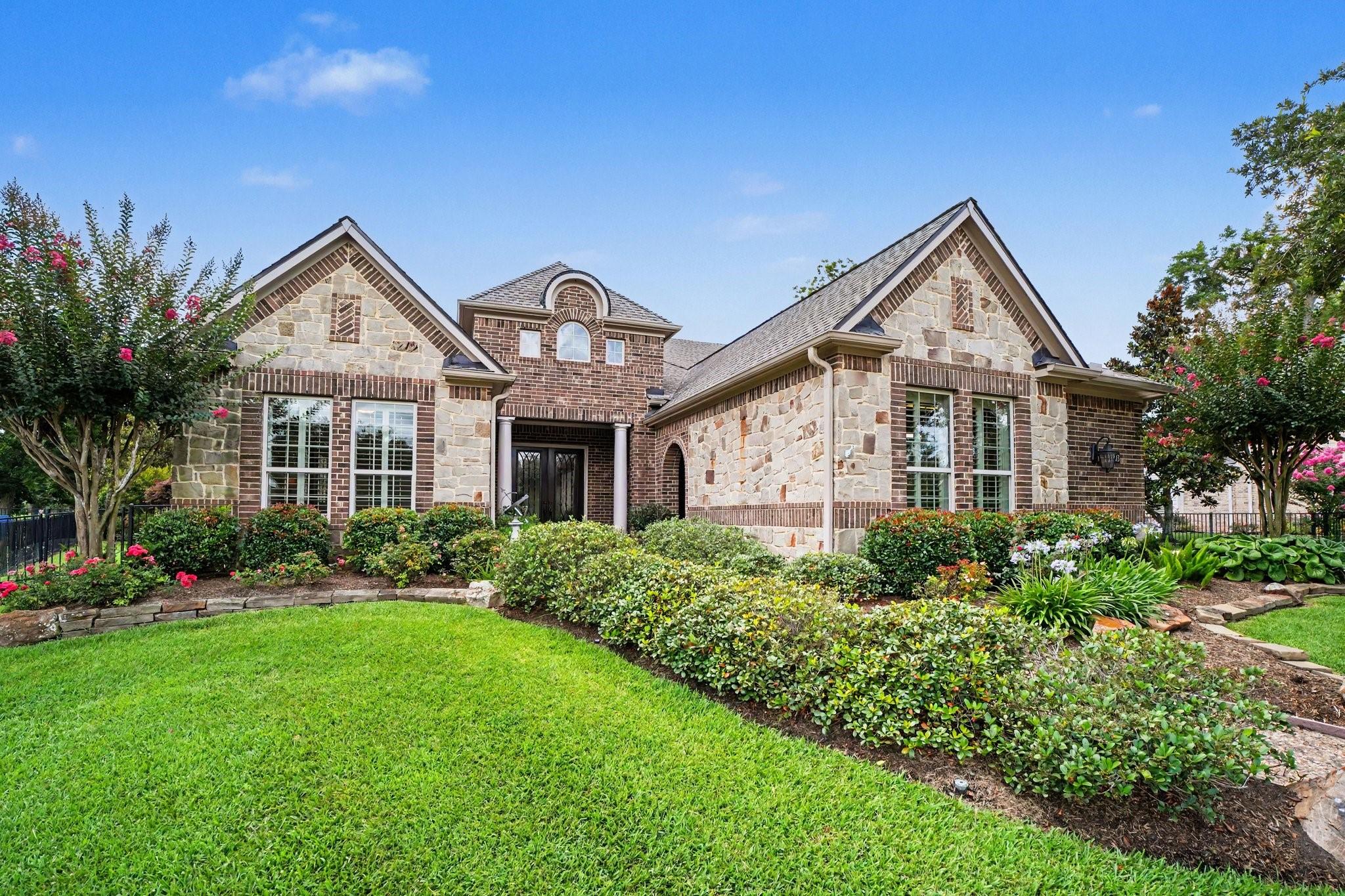 Image 1: This charming home features a beautiful brick and