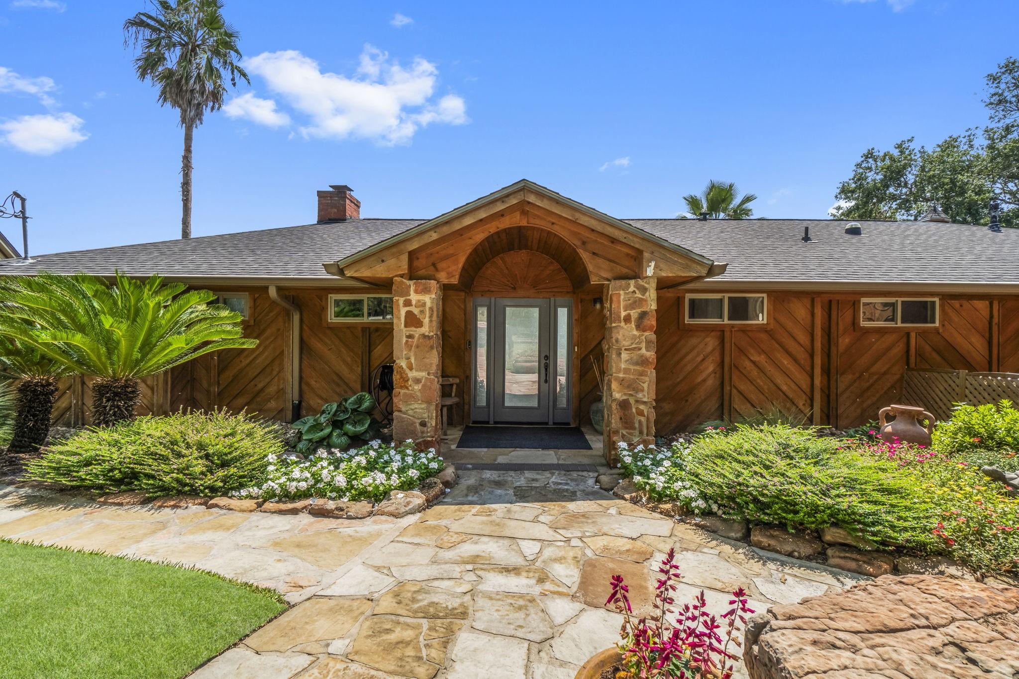 Image 1: Charming single-story home with a rustic stone and