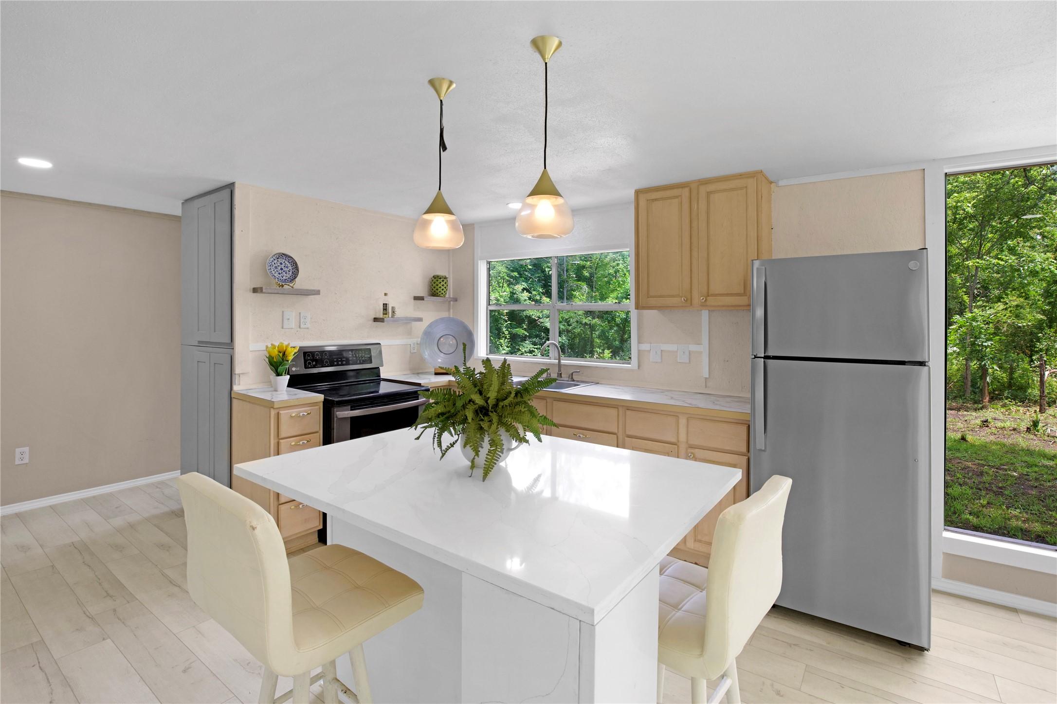 Image 3: Kitchen features quartz countertops and central is