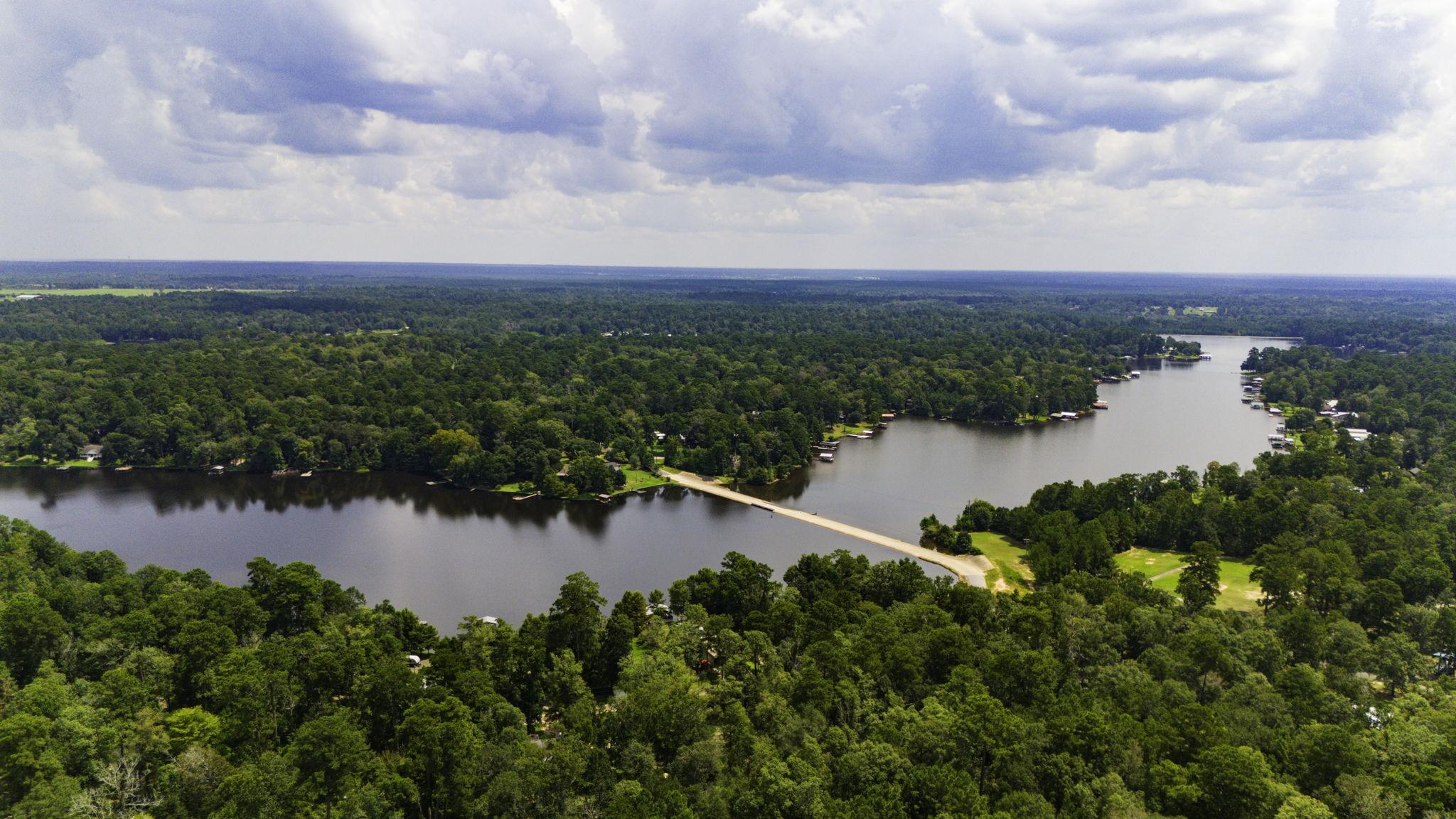 Image 4: Aerial view of a serene, wooded area featuring a l