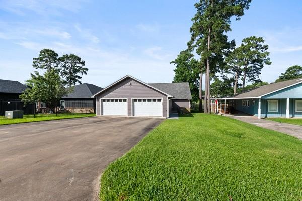 Image 4: Spacious driveway leading to a three-car garage at