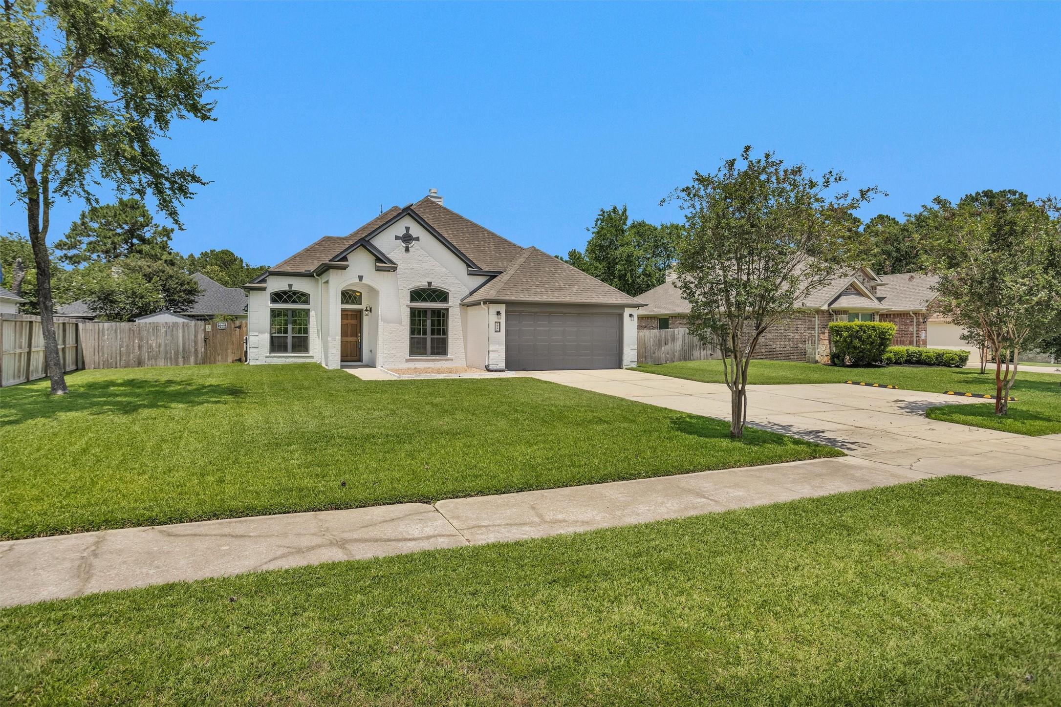 Image 2: Side view with driveway and 2-car garage