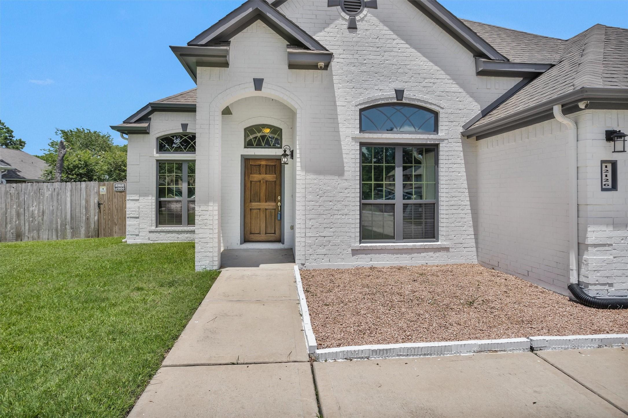 Image 3: Welcoming wood front door with decorative glass an