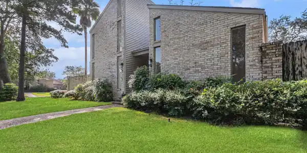 Image 3: Modern brick home with a sleek design, surrounded