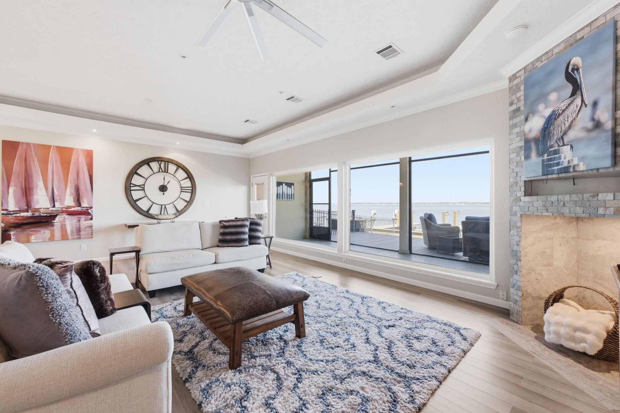 Image 3: Spacious living area with tray ceilings, wood-look