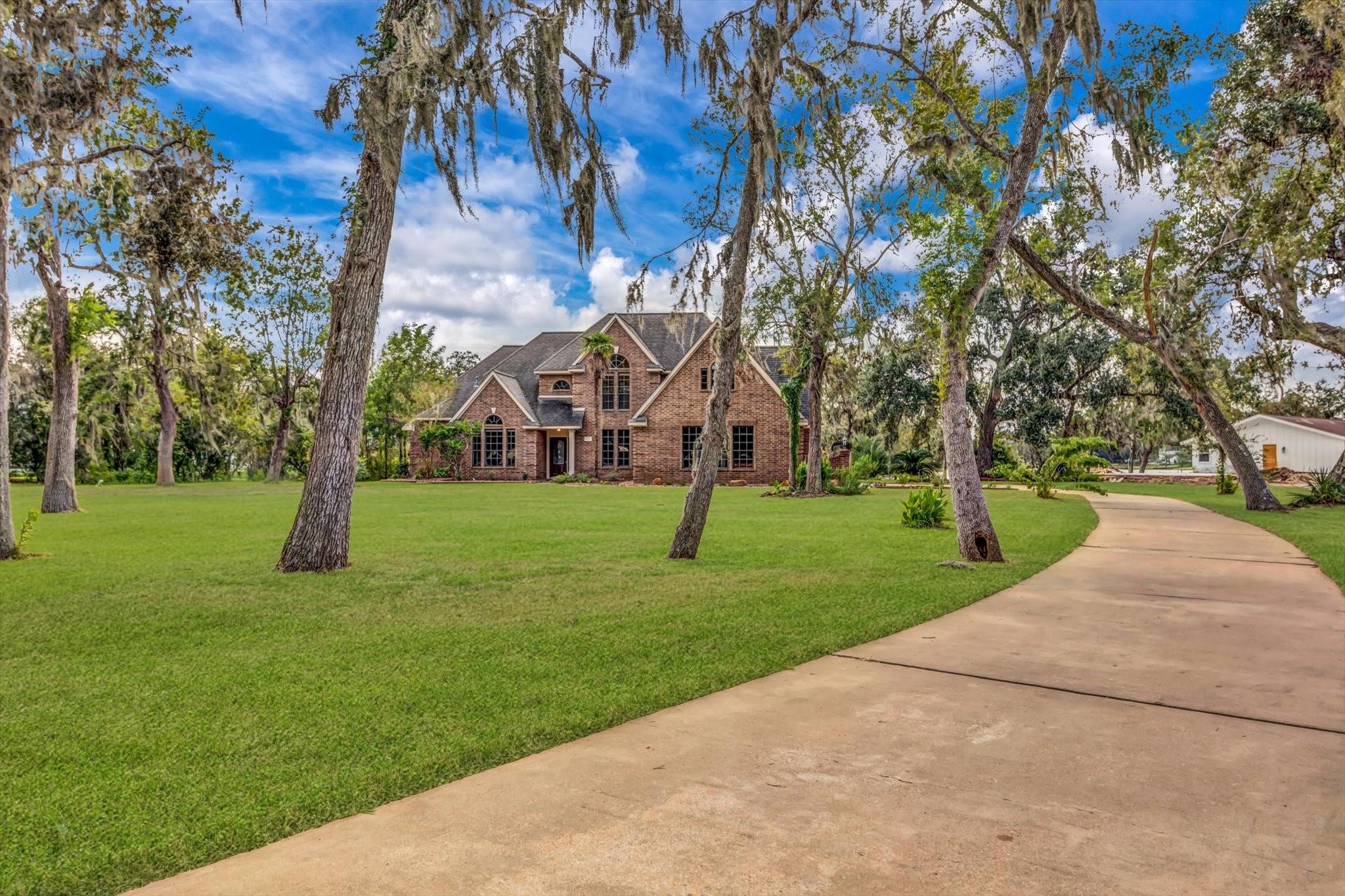 Image 1: This is a spacious two-story brick home with a lar