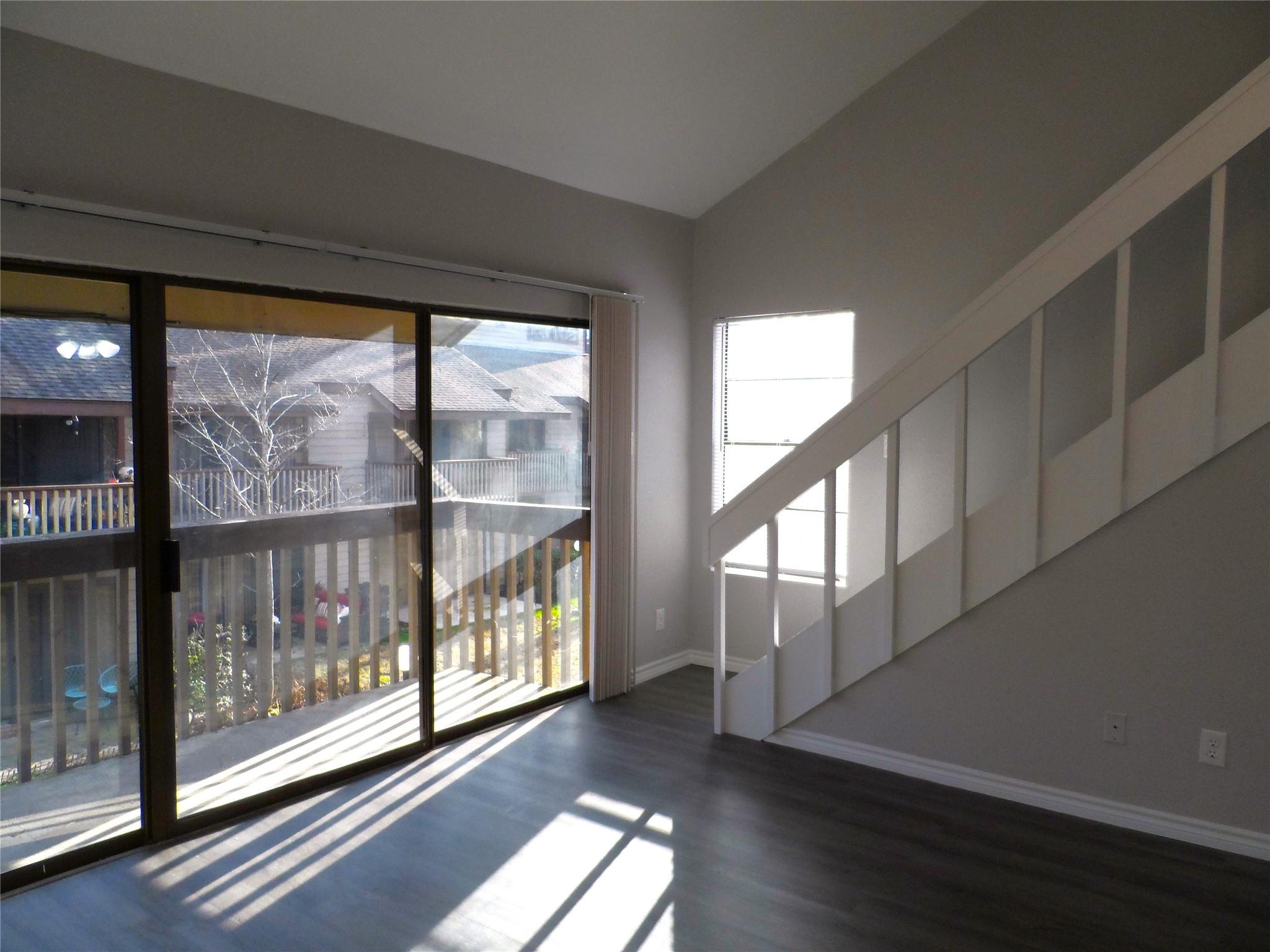 Image 2: Bright and open living area featuring wood-look fl