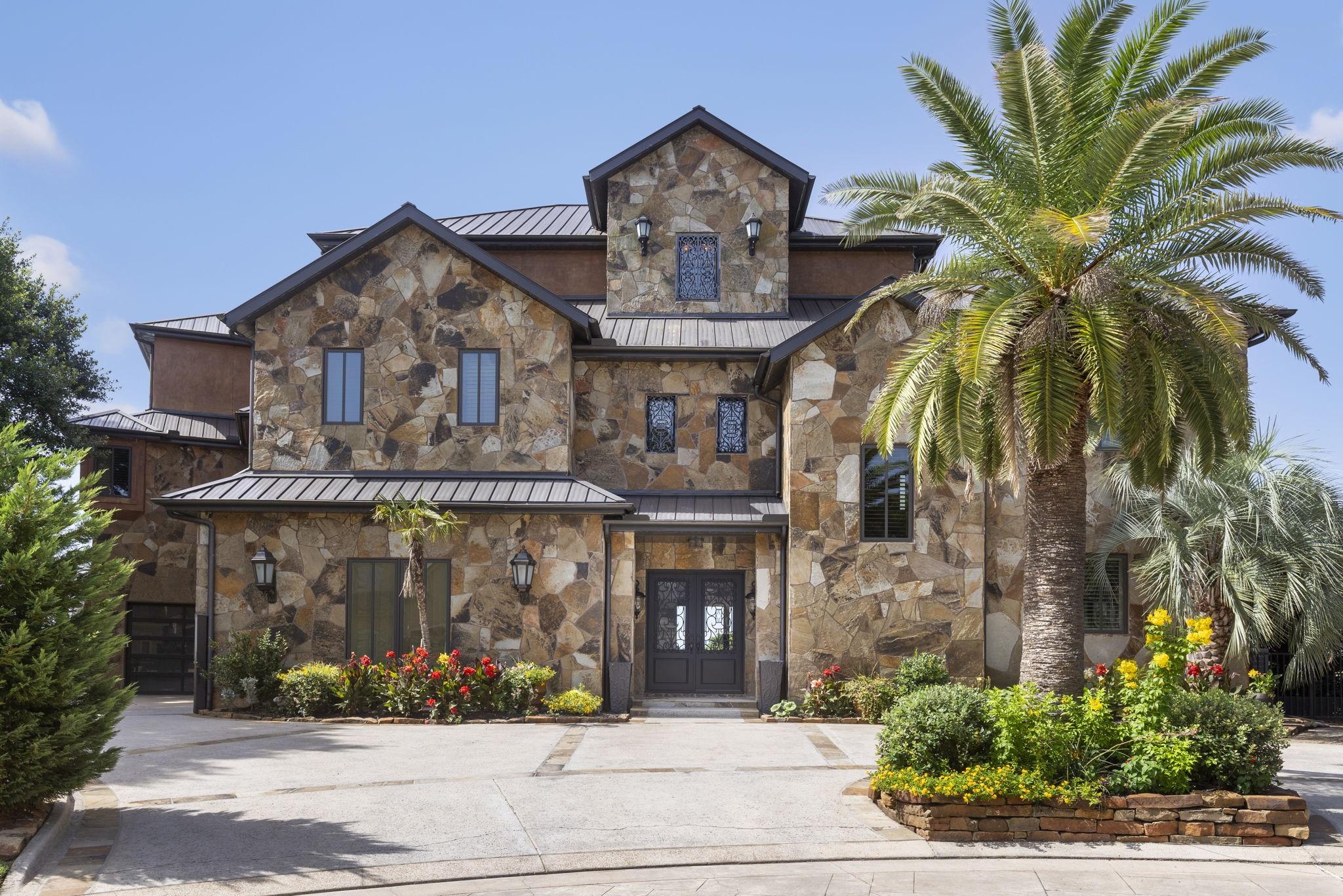 Image 3: Framed by manicured landscaping, tropical palms, a