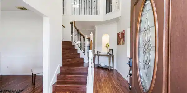 Image 4: Elegant entryway with rich wood flooring and a gra