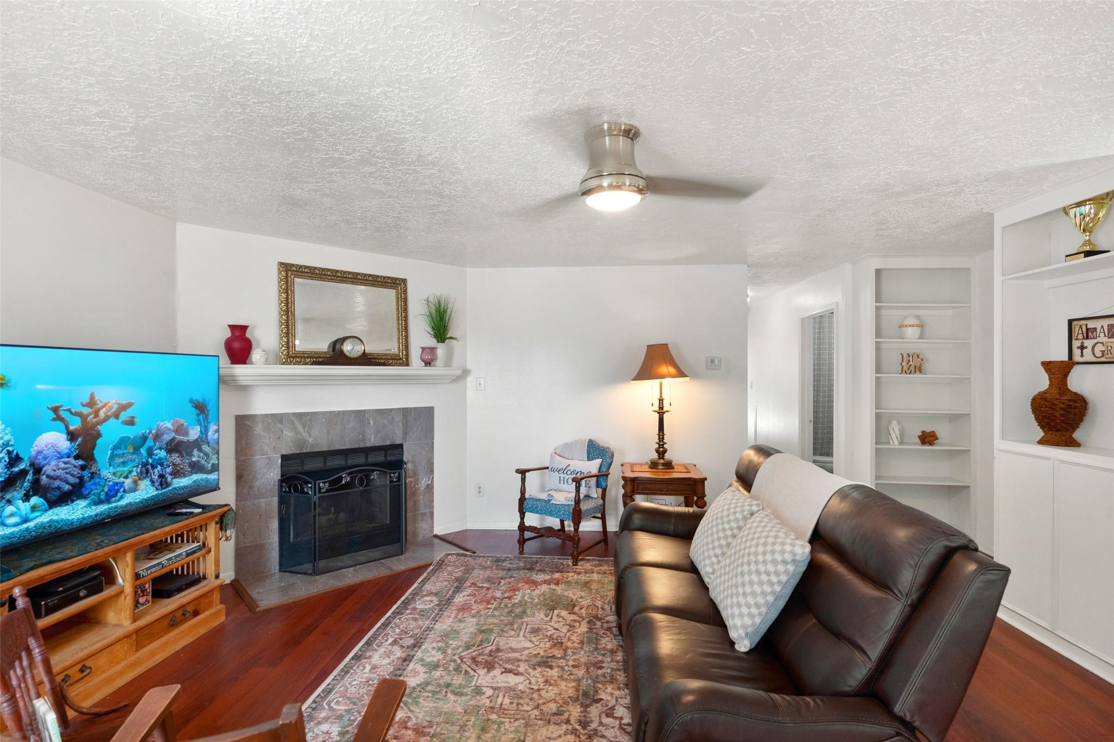 Image 3: Cozy living area featuring a charming fireplace, e