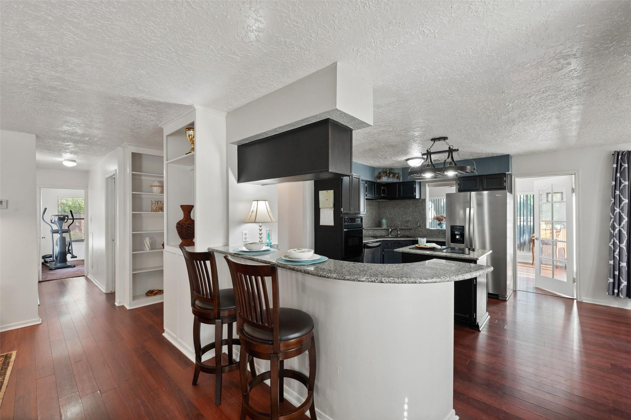 Image 4: Modern kitchen with sleek countertops and an adjac