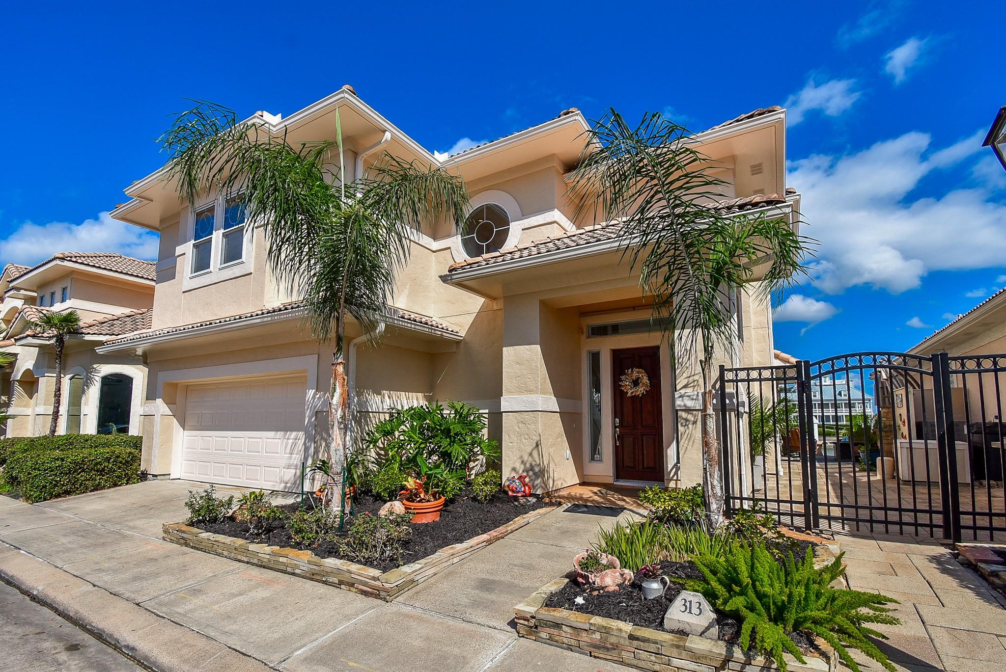 Image 3: Stucco exterior and lush landscaping show the atte