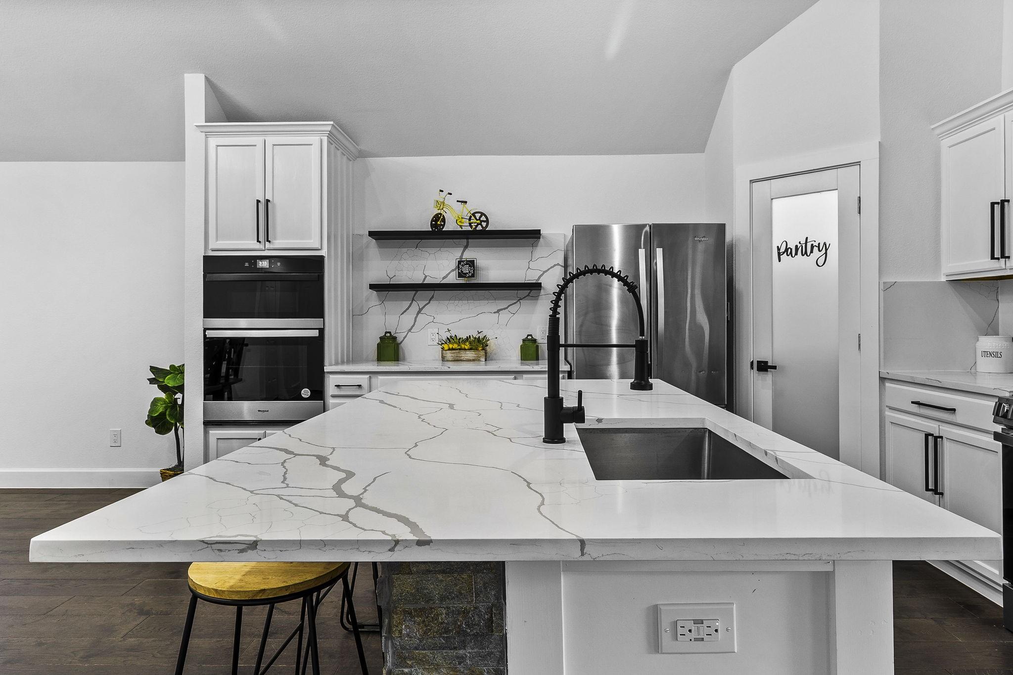 Image 2: This modern kitchen features sleek white cabinetry