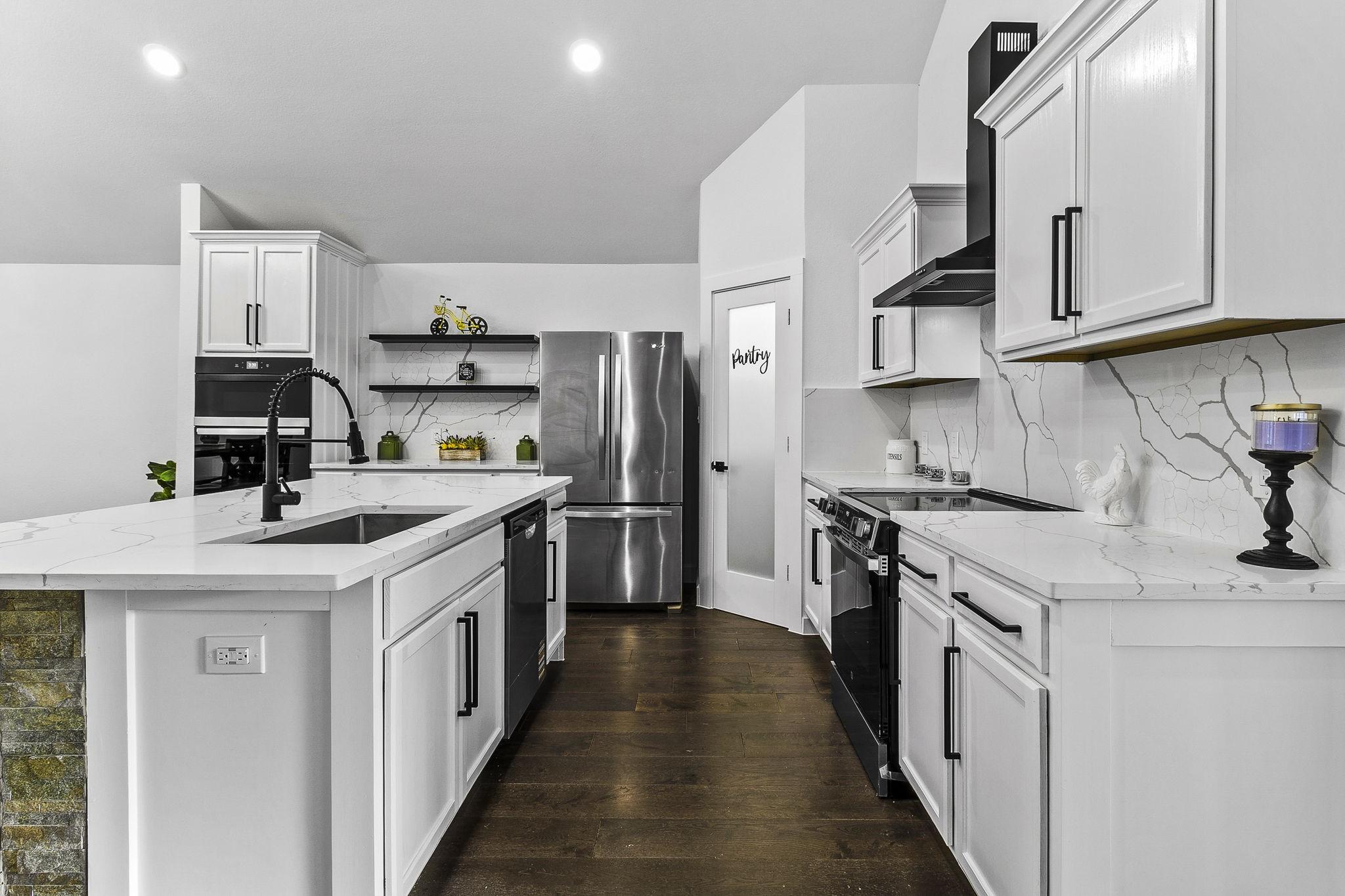Image 4: This modern kitchen features sleek white cabinetry