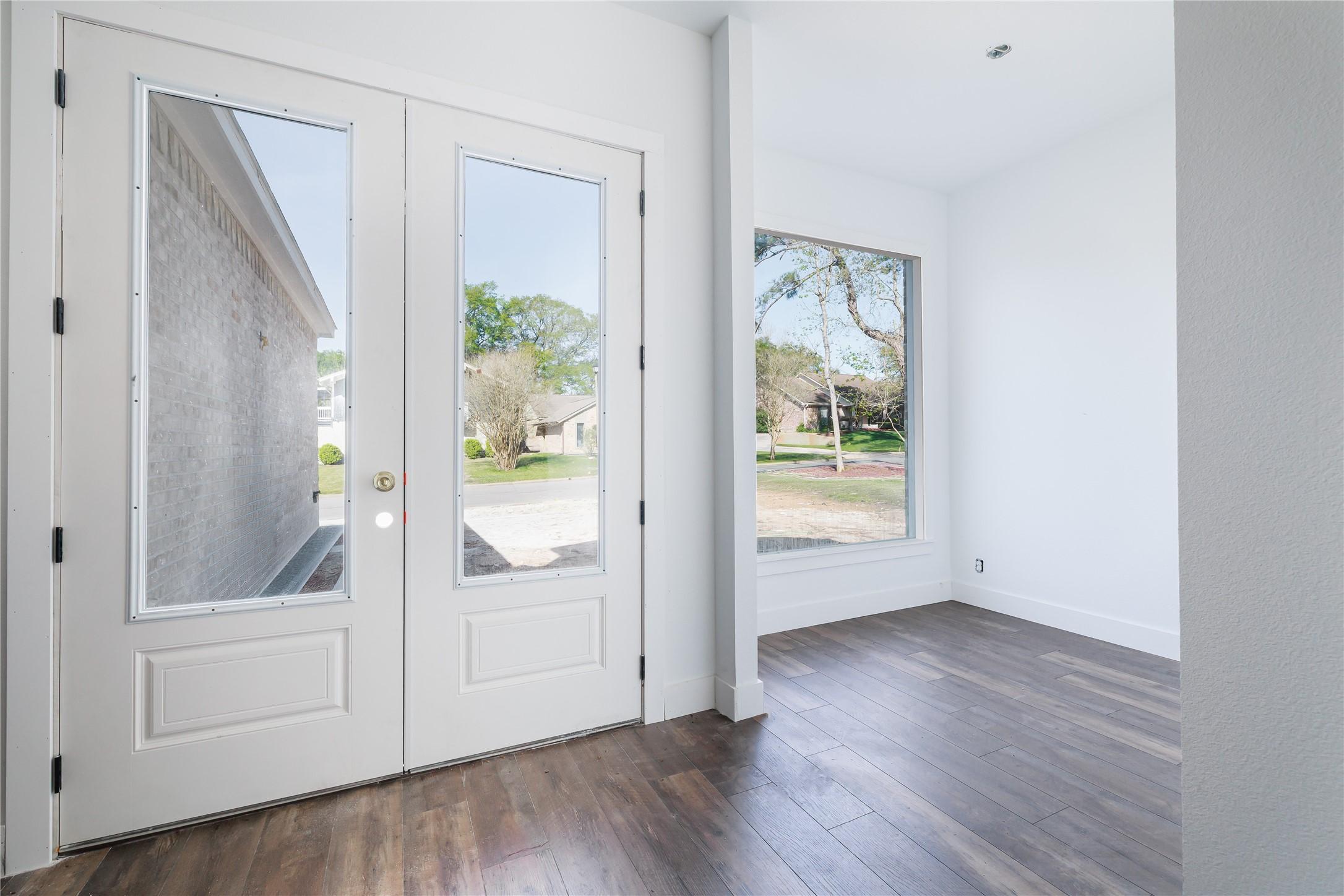 Image 2: Sun-filled entry framed by glass doors that invite