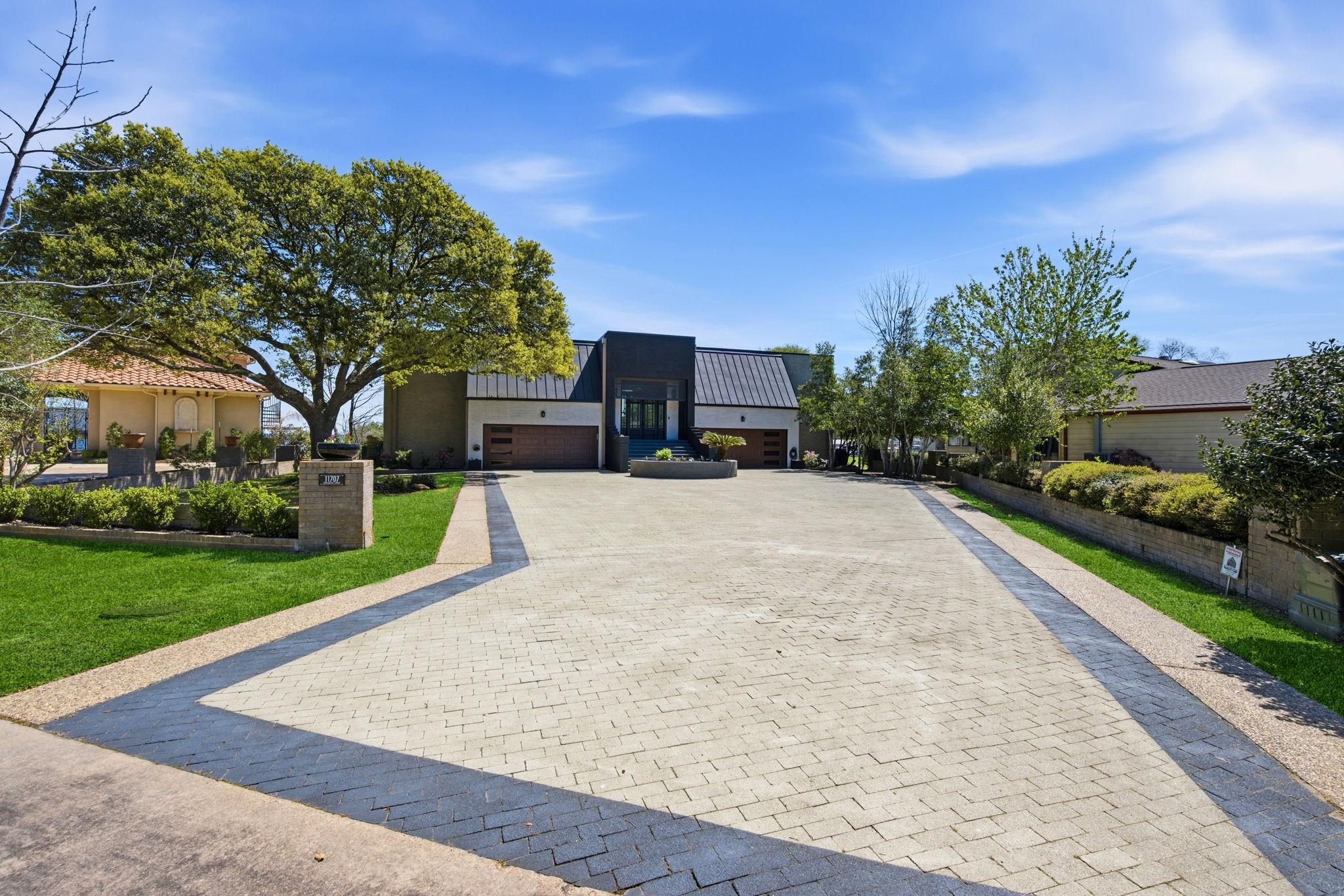 Image 2: Grand driveway showcasing 4 car garage