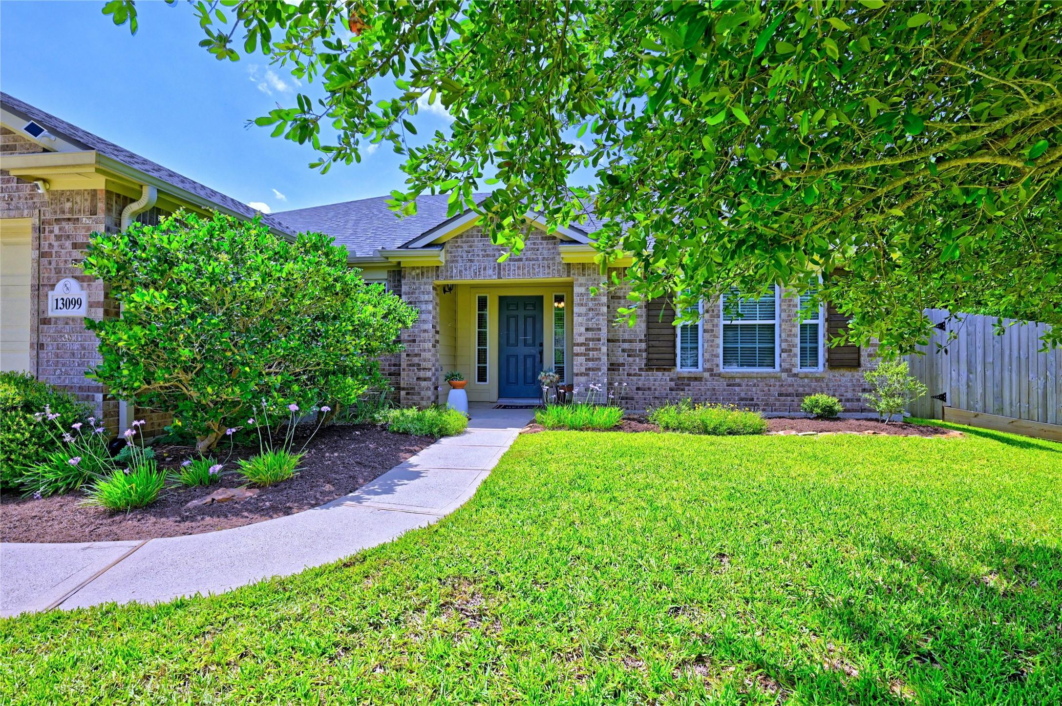 Image 2: Charming brick home with a welcoming front path, f