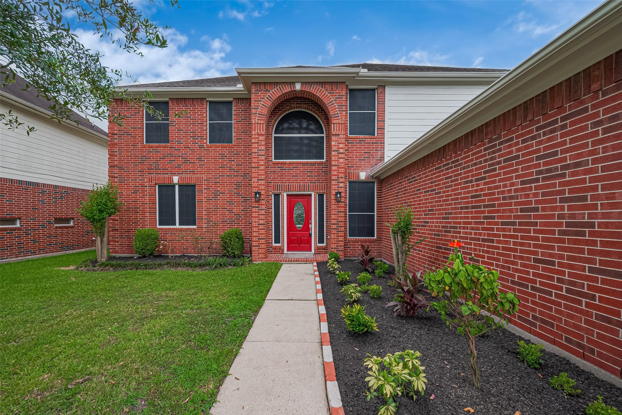 Image 3: An inviting pathway winds through front yard leadi