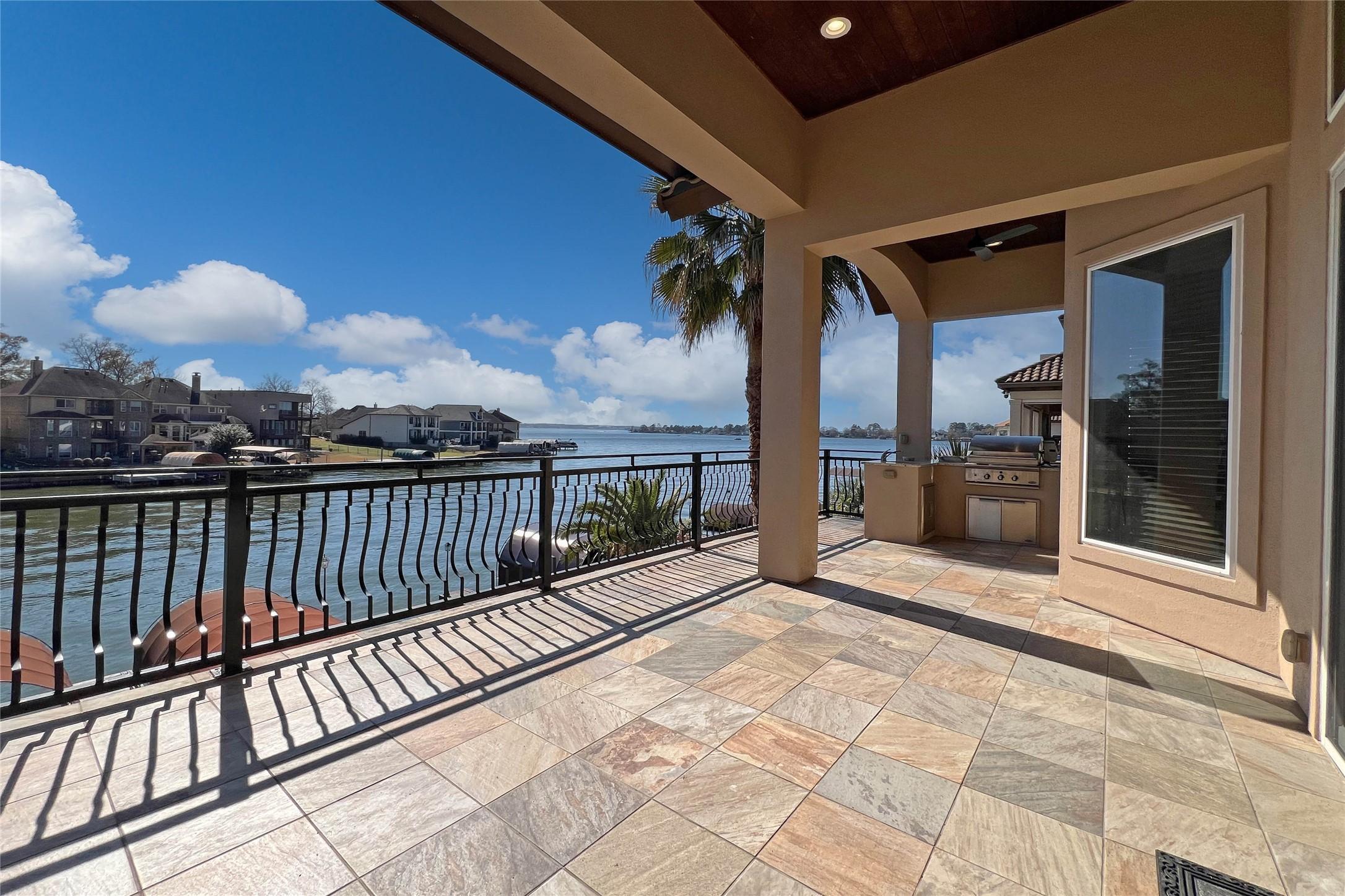 Image 1: This photo shows a spacious waterfront terrace wit