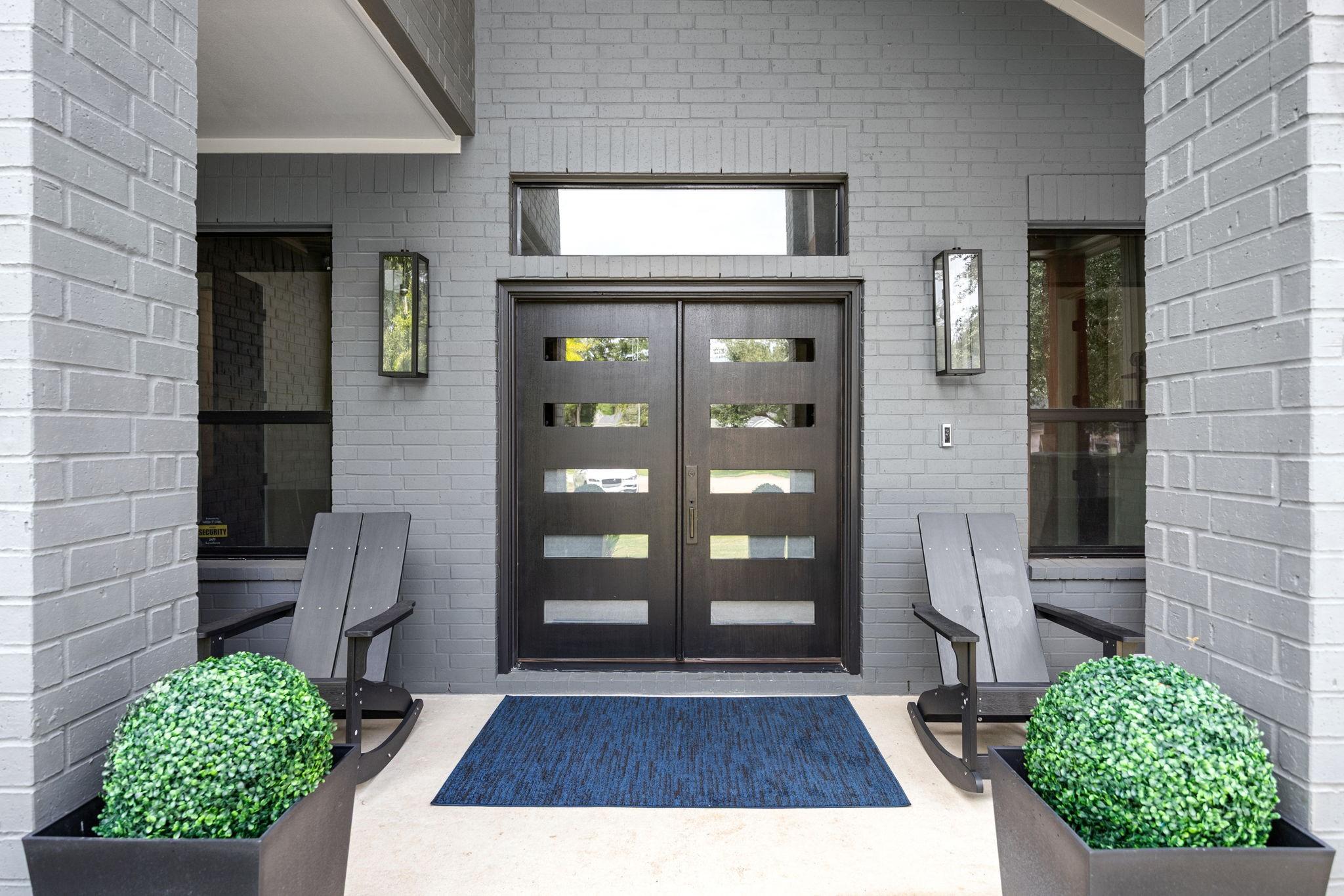 Image 4: Modern front entrance with a sleek dark double doo