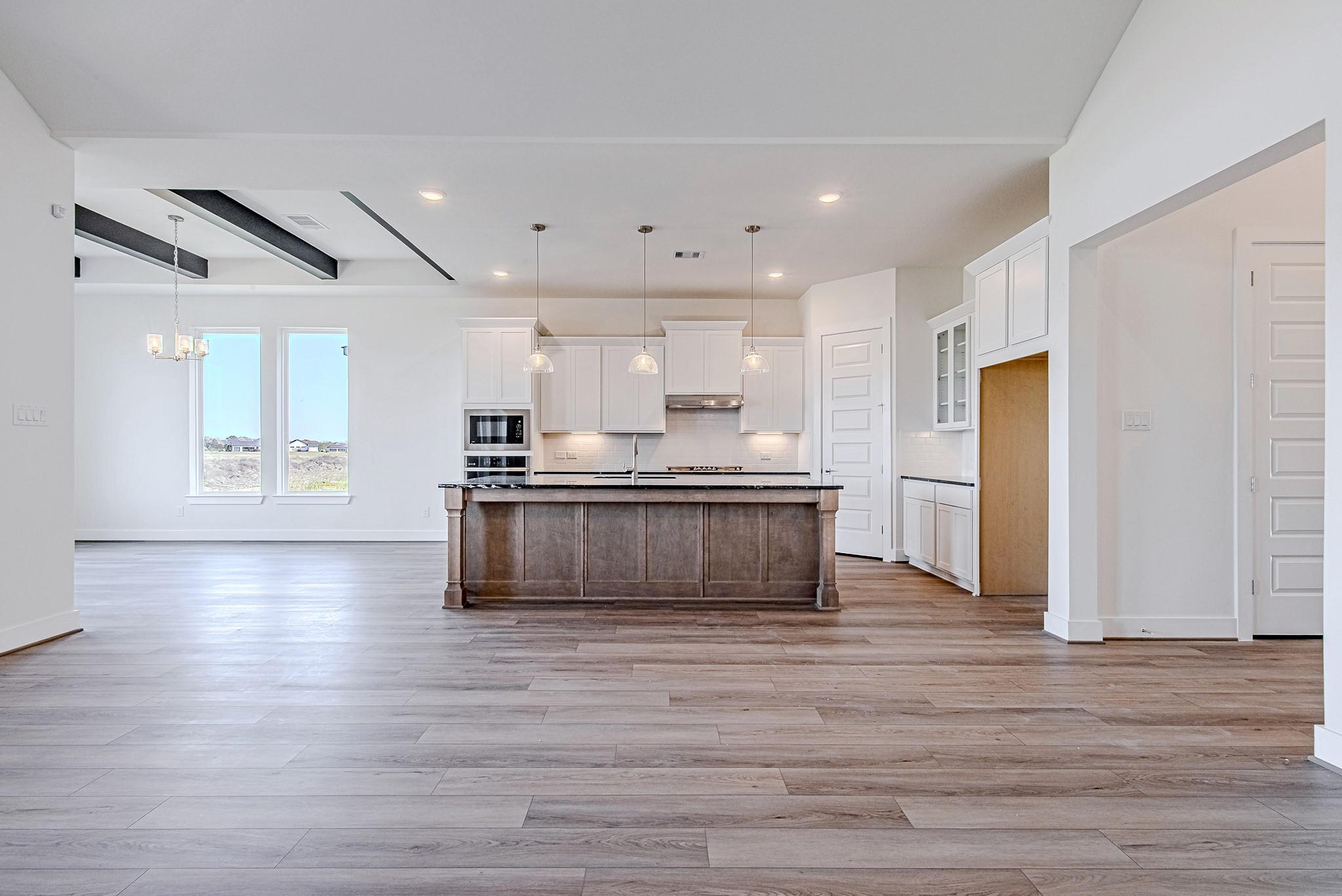 Image 3: Wide-angle view of open-concept living and kitchen