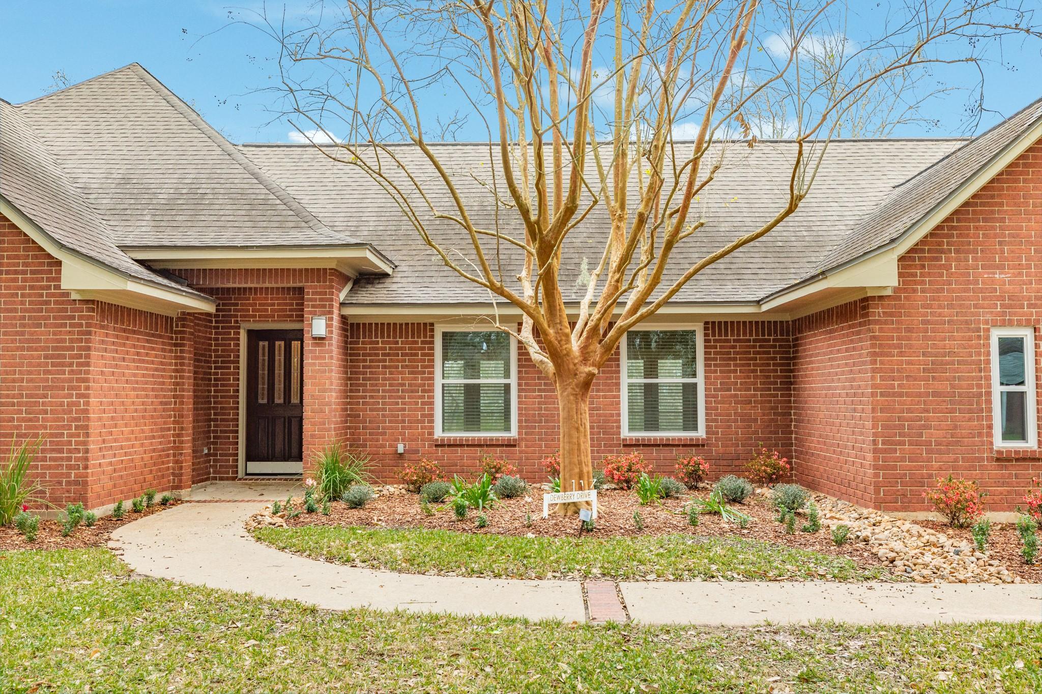 Image 2: This photo features a charming brick home with a g