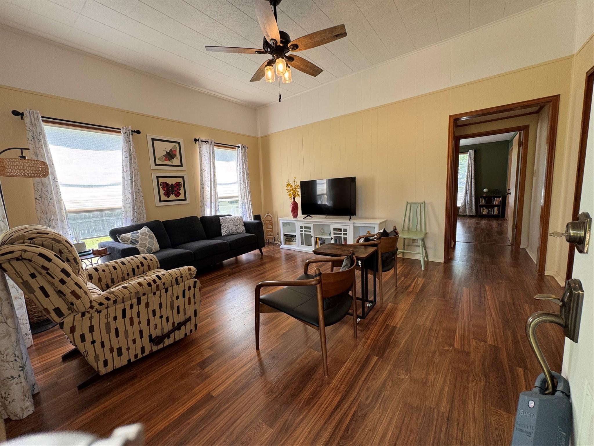 Image 4: This inviting living room features warm wood floor