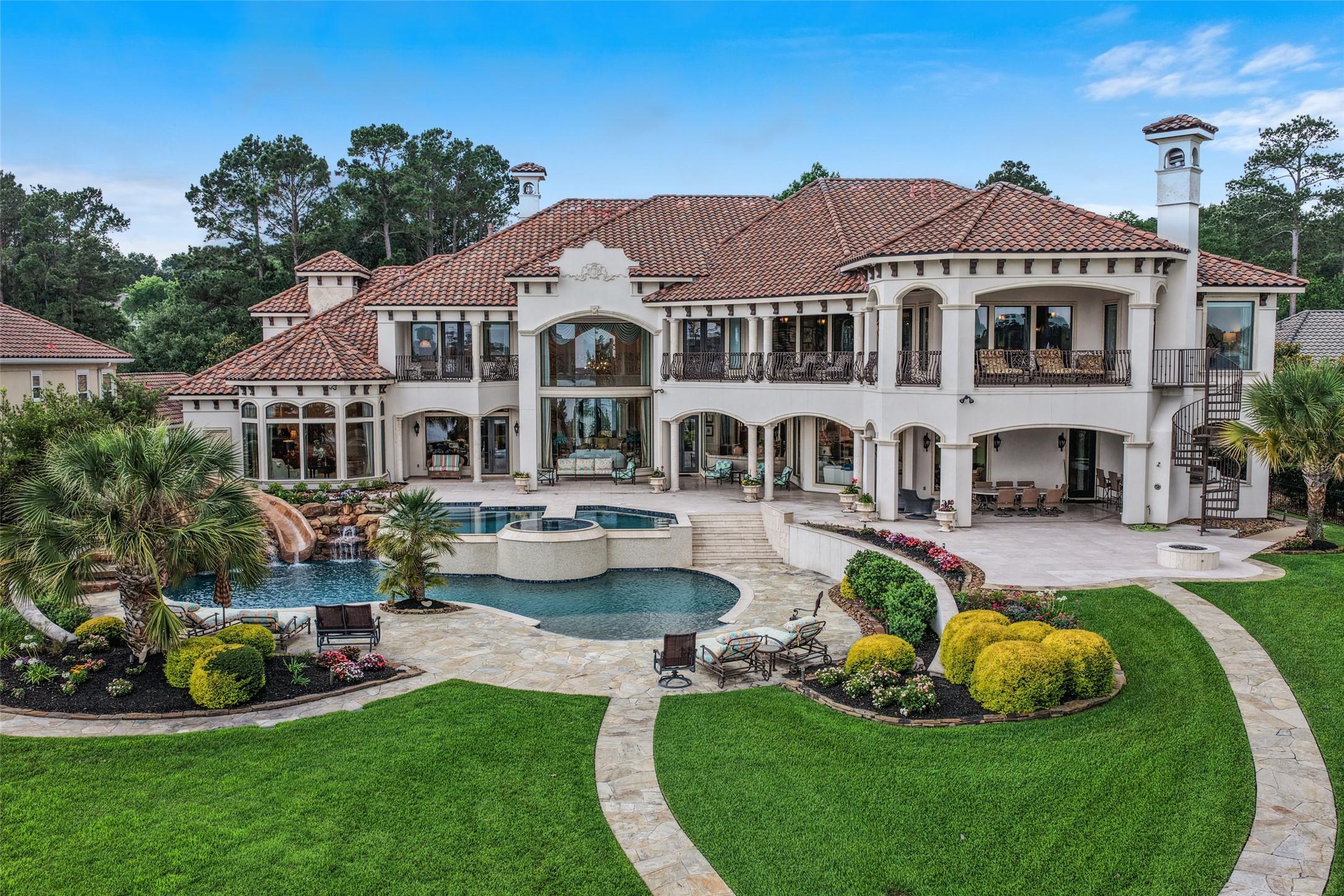 Image 1: This luxurious estate features a grand two-story h
