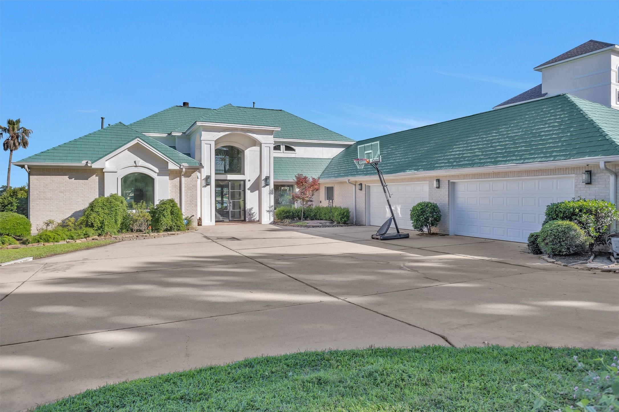 Image 2: This spacious home features a large driveway leadi