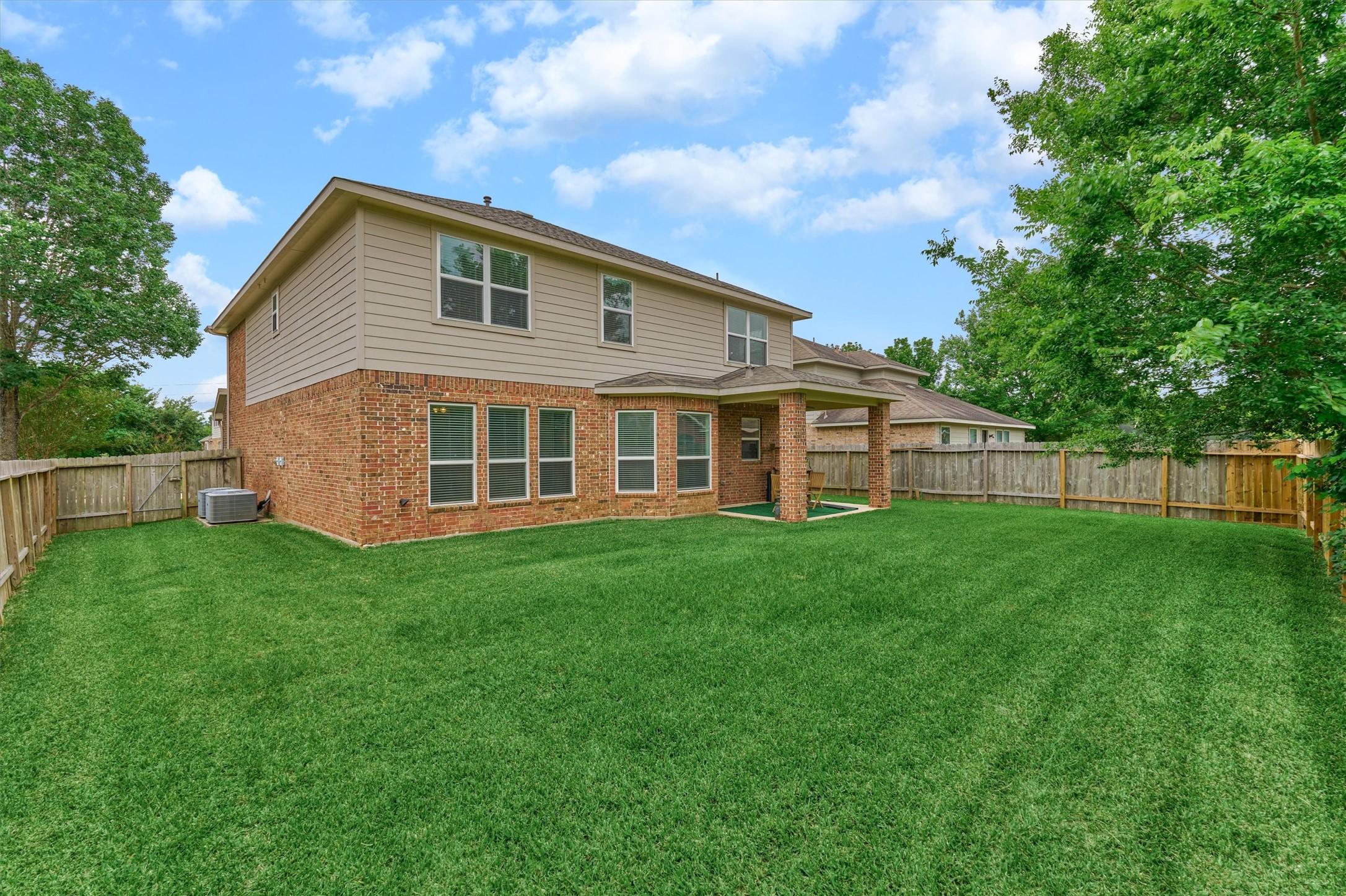 Image 3: An oversized backyard offers ample green space for