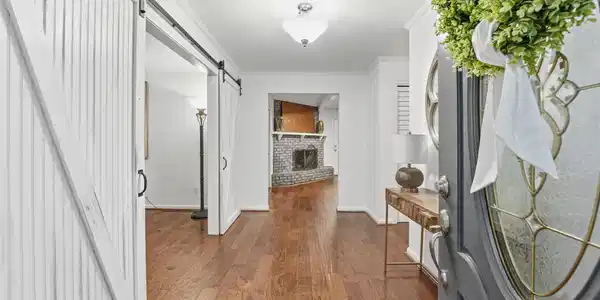 Image 3: Warm hardwood floors and a classic brick fireplace