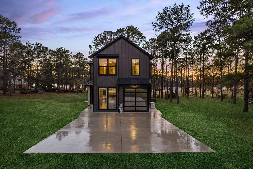 Image 1: This modern home features a sleek, dark exterior w